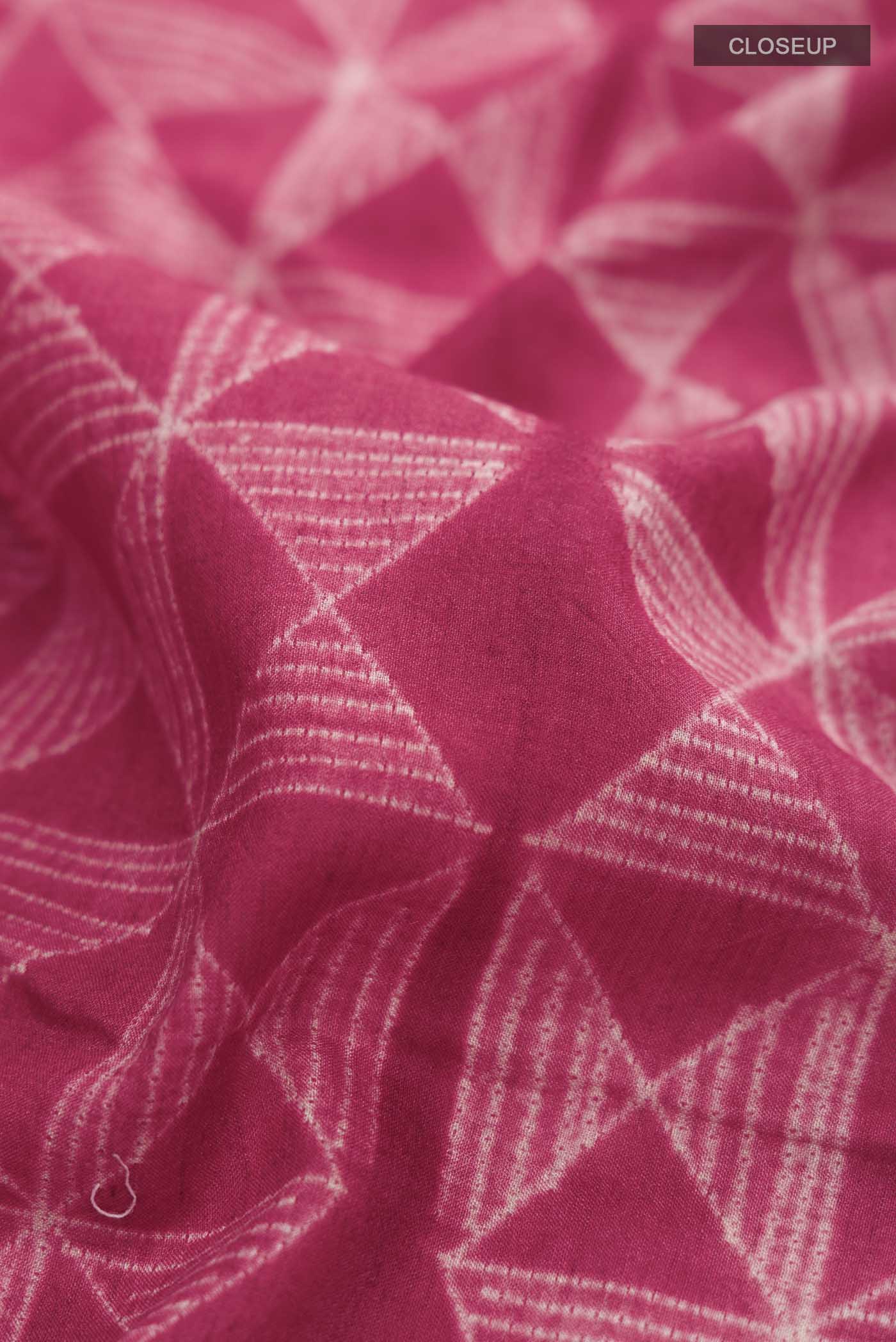 Close up of Red Tussar Silk Saree Printed design on the body and Plain Border displaying folds