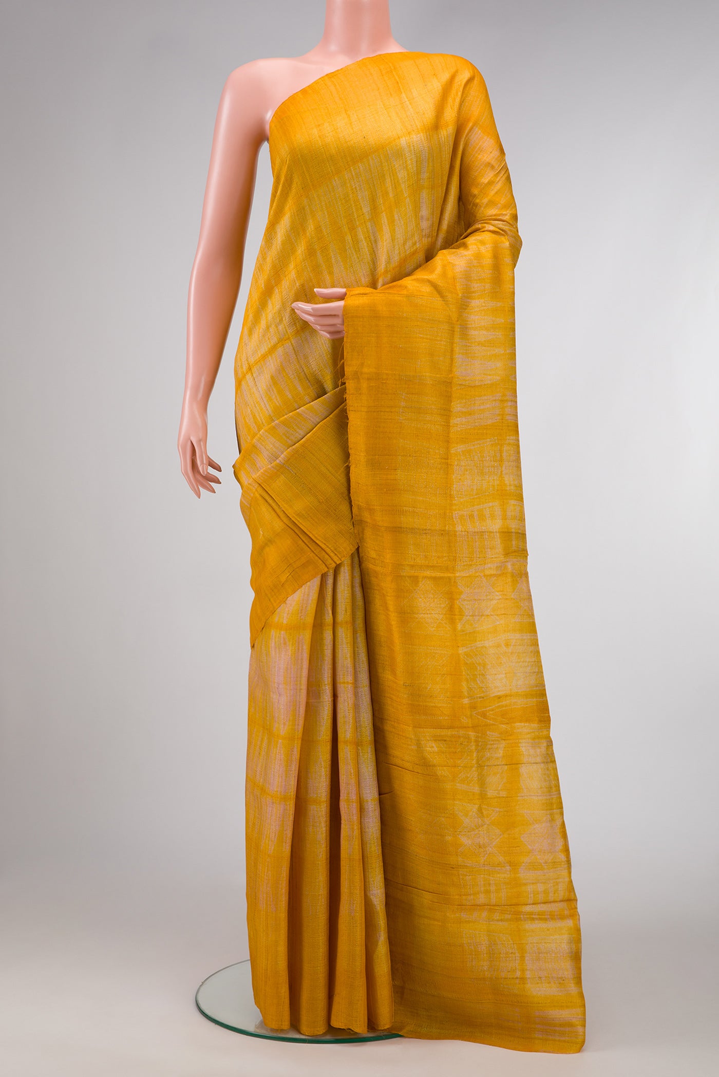 Mustard Dual Tone Tussar Silk Saree with Printed design on the body and Without Border.  displayed on a mannequin