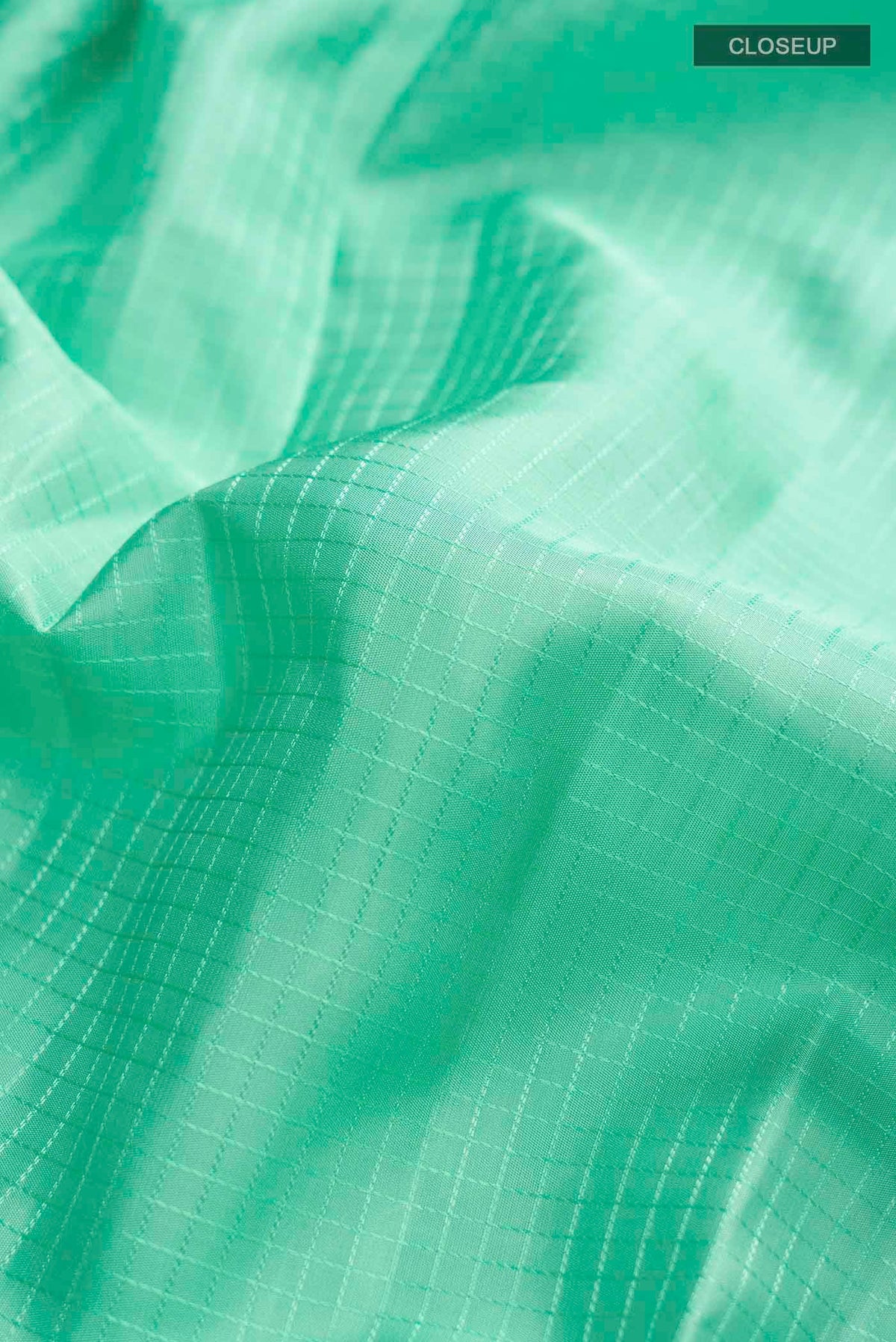 Close up of Mint Green Kanchipuram Silk Saree with Checked design on the body and Zari Border displaying folds