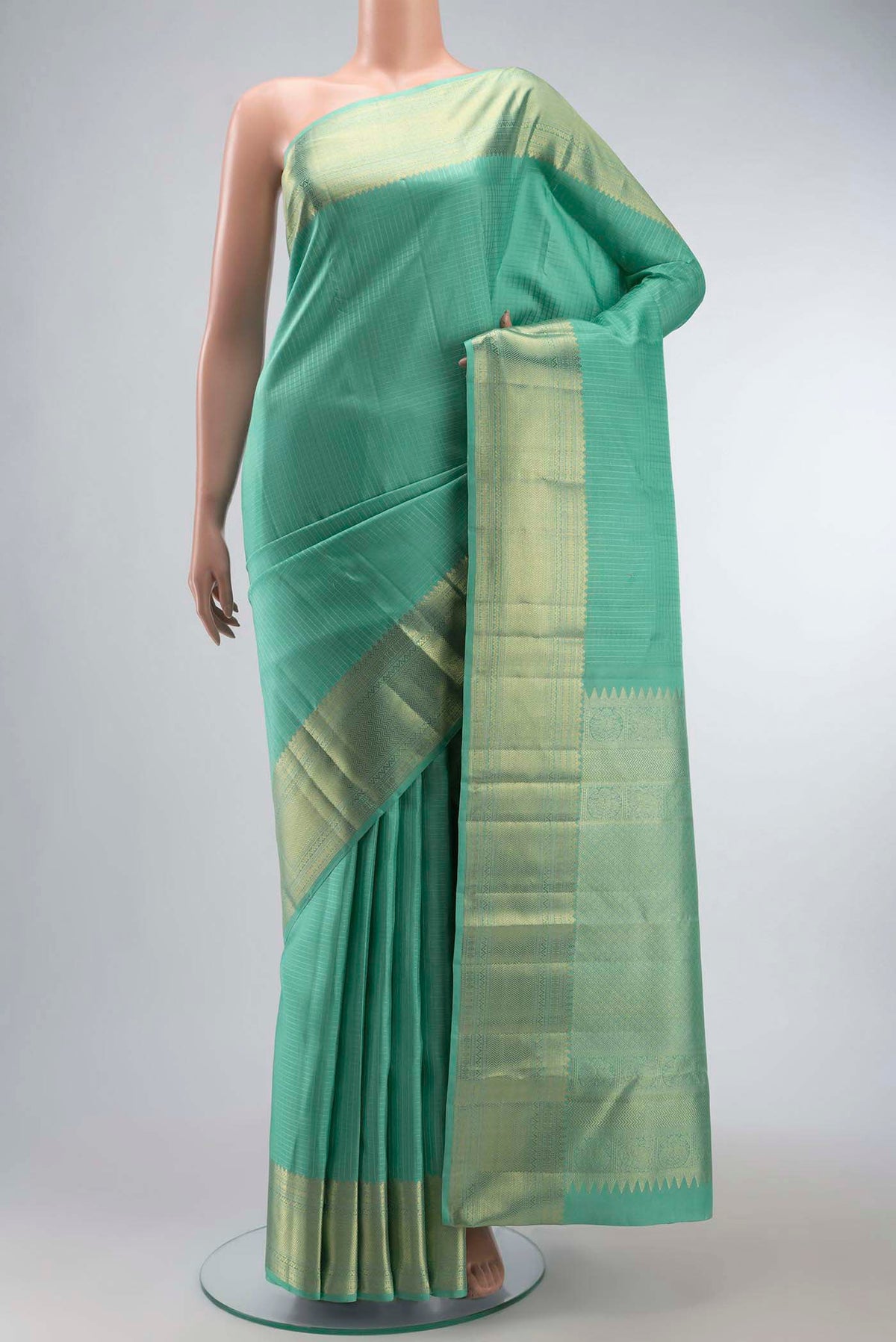 Mint Green Kanchipuram Silk Saree with Checked design on the body and Zari Border displayed on a mannequin