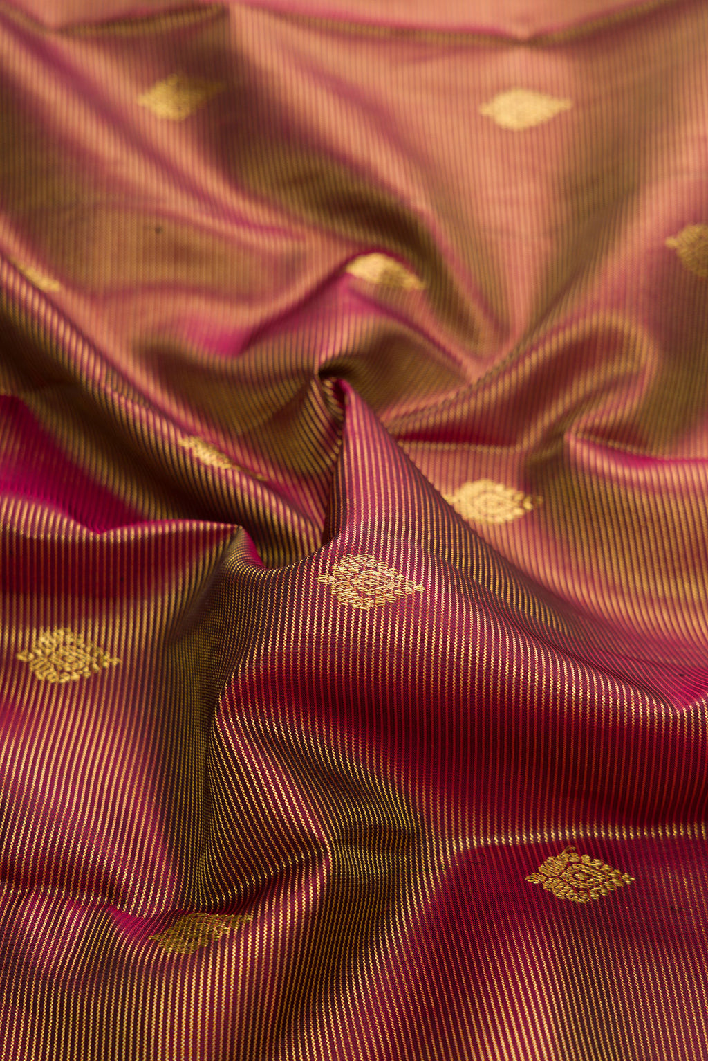 Close up of Maroon Dual Tone Kanchipuram Silk Saree with Zari Butta on the body and Zari Border.  displaying folds