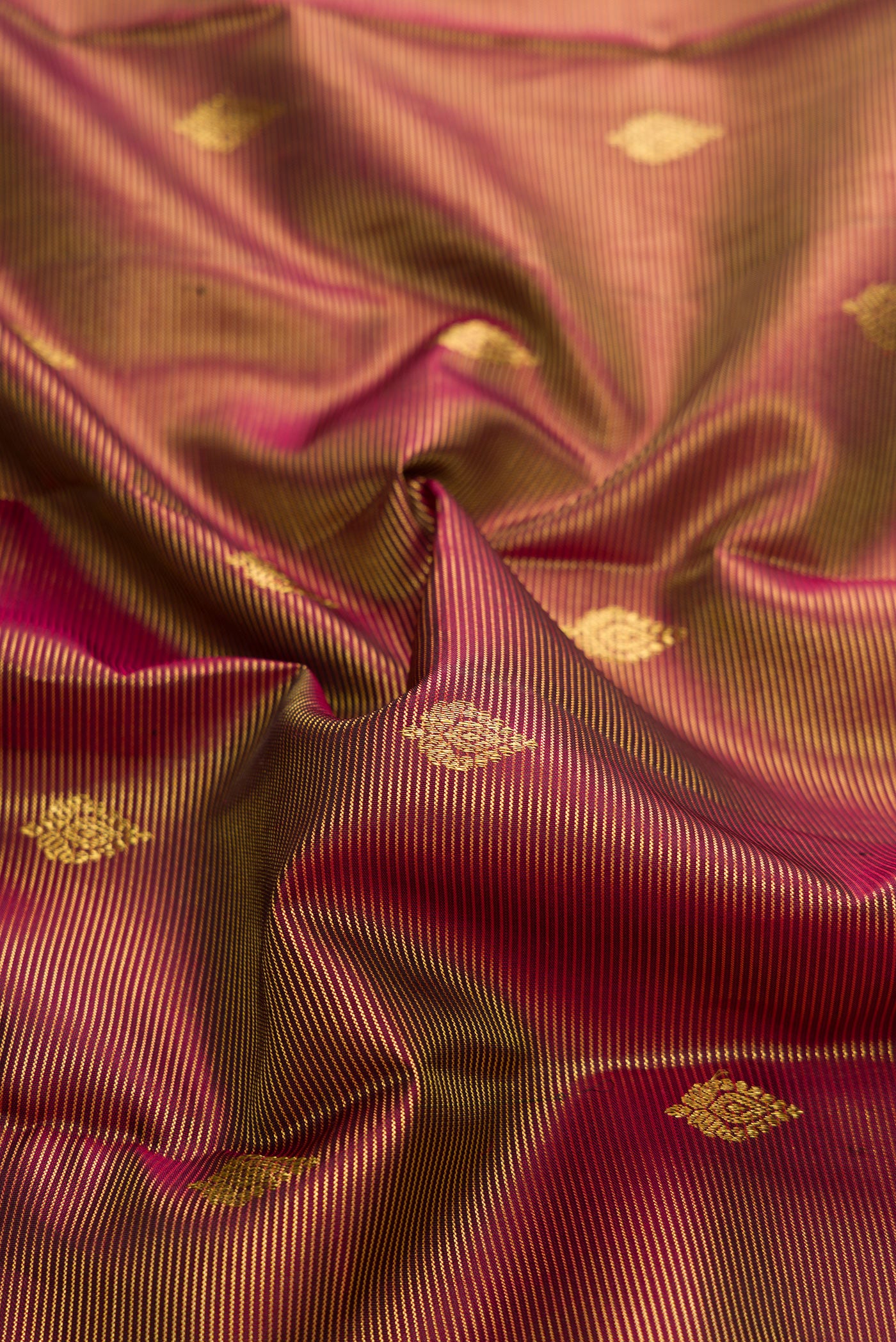 Close up of Maroon Dual Tone Kanchipuram Silk Saree with Zari Butta on the body and Zari Border.  displaying folds