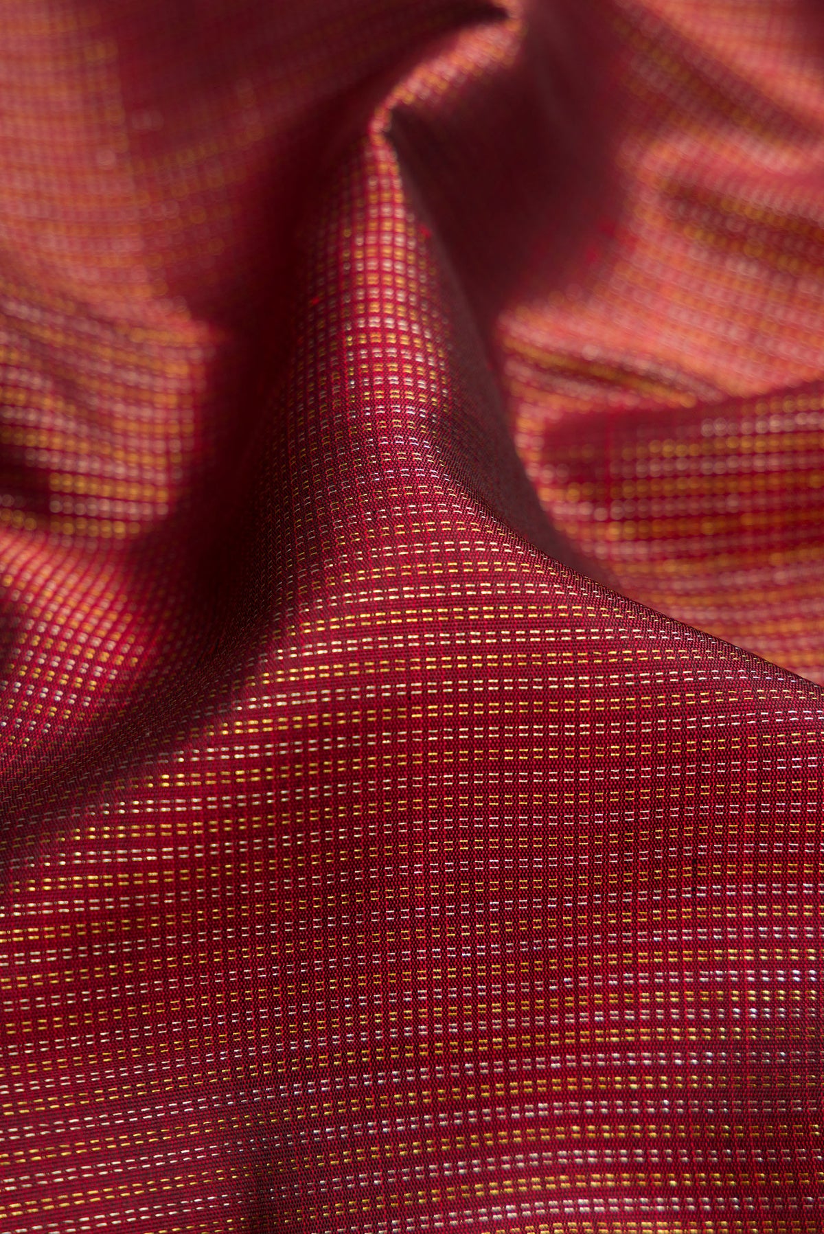 Close up of Maroon Dual Tone Kanchipuram Silk Saree with Stripes on the body and Zari Border.  displaying folds