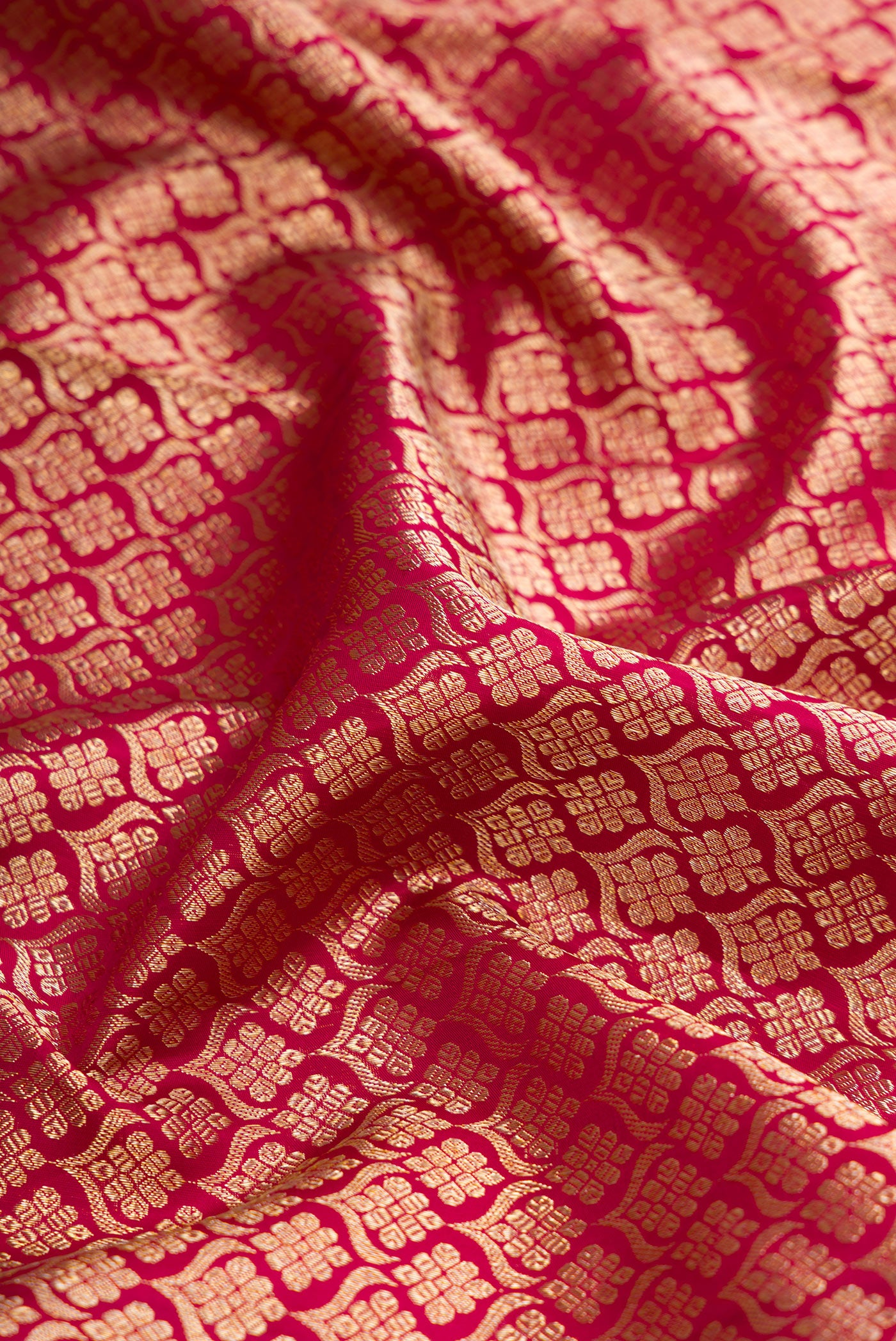 Close up of Magenta Dual Tone Kanjivaram Silk Saree with Zari Brocade on the body and Zari Border.  displaying folds