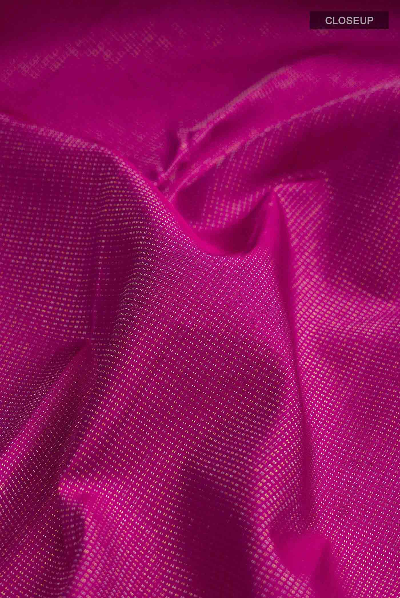 Close up of Pink Kanchipuram Silk Saree with Zari Butta on the body and Zari Border displaying folds