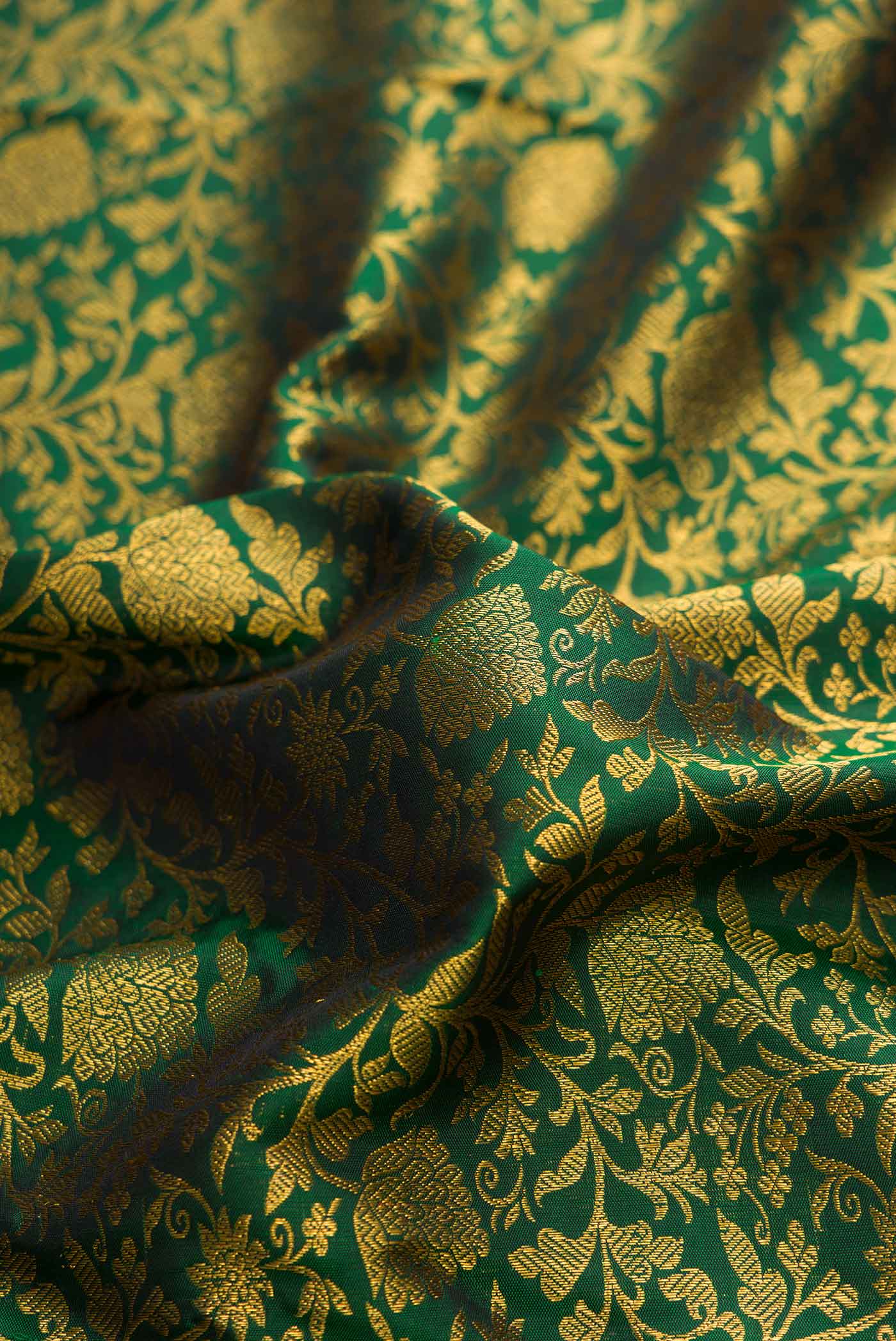 Close up of Pure Silk Pure Zari Green Dual Tone Kanchipuram Saree with Zari Brocade on the body and Zari Border displaying folds