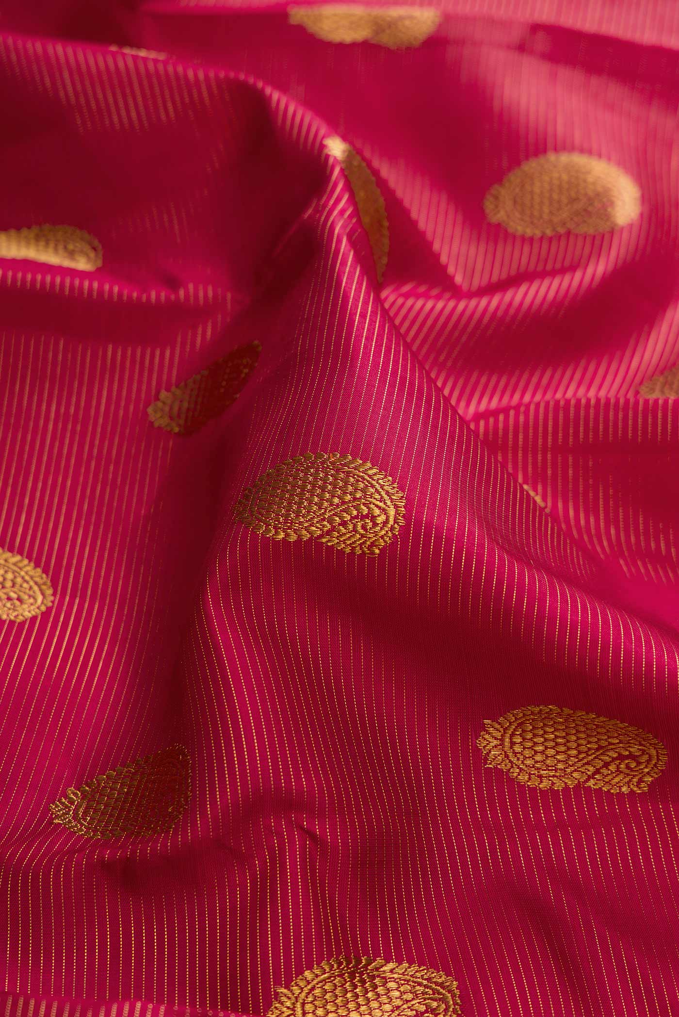 Close up of Pure Silk Pure Zari Red Dual Tone Kanchipuram Saree with Zari Butta on the body and Zari Border displaying folds