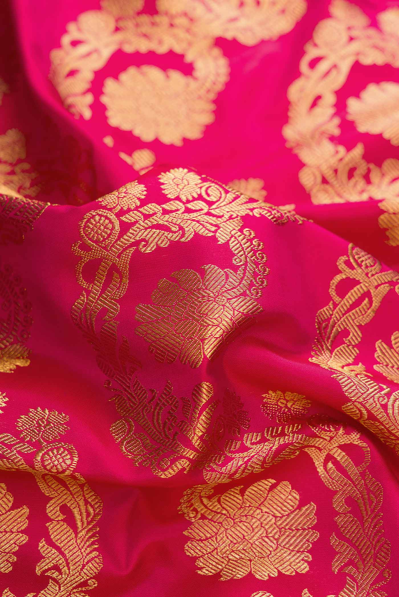 Close up of Pure Silk Pure Zari Dark Pink Dual Tone Kanchipuram Saree with Zari Brocade on the body and Zari Border displaying folds