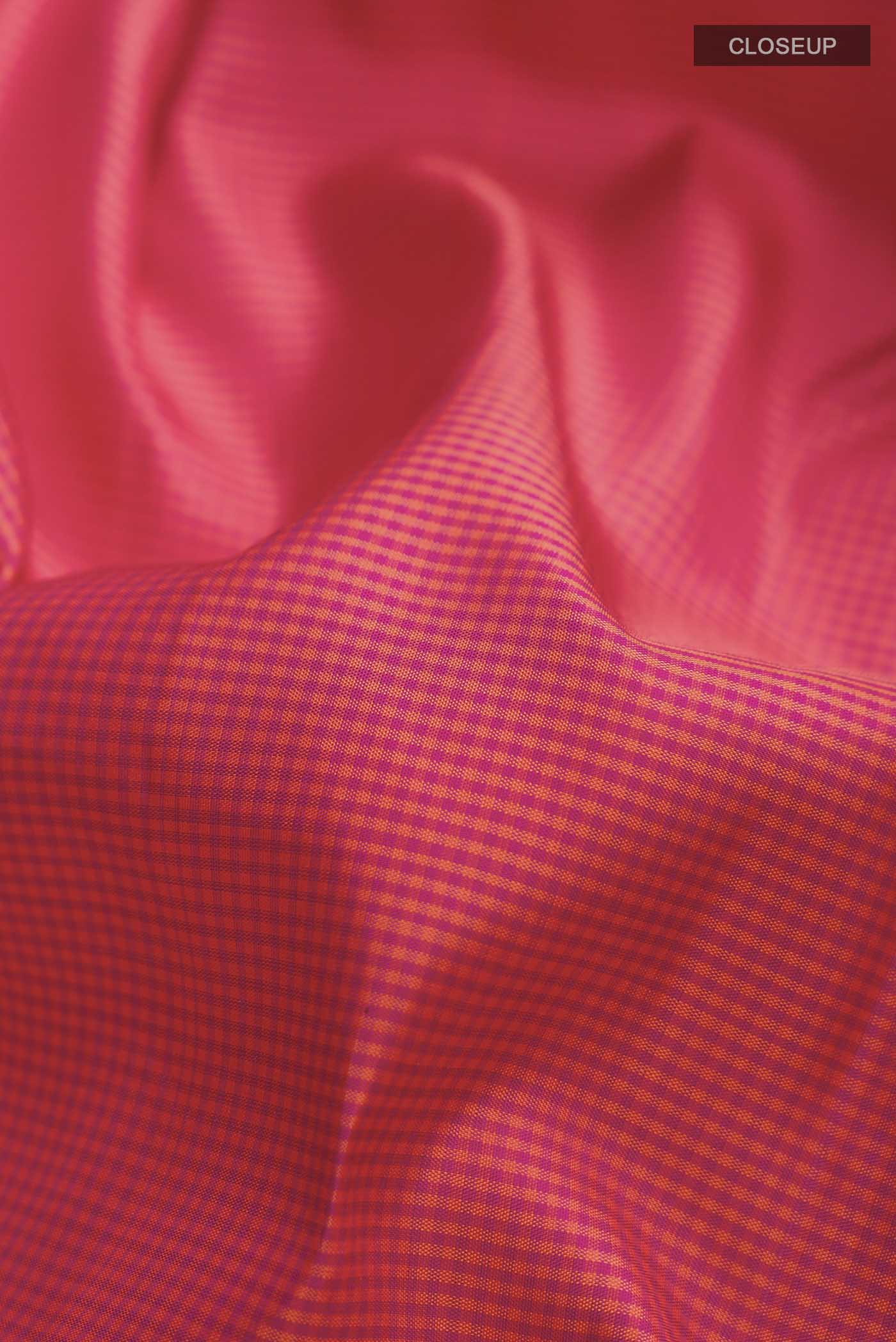 Close up of Pink Kanchipuram Silk Saree with Checked design on the body and Zari Border displaying folds