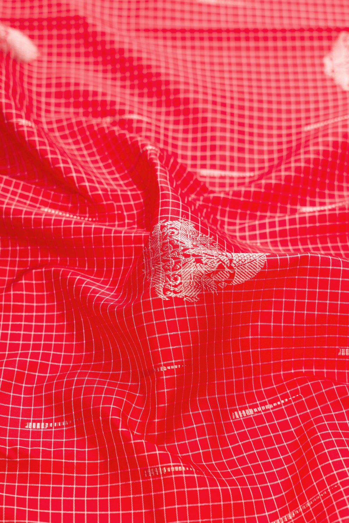 Close up of Pure Silk Pure Zari Red Dual Tone Kanjivaram Saree with Zari Butta on the body and Without Border.  displaying folds
