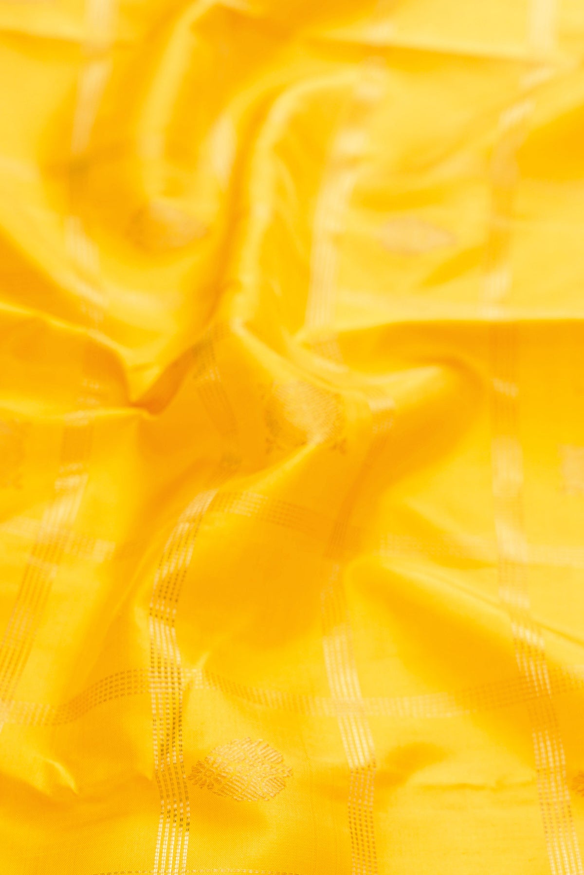 Close up of Pure Silk Pure Zari Yellow Dual Tone Kanchipuram Saree with Checked design on the body and Zari Border displaying folds