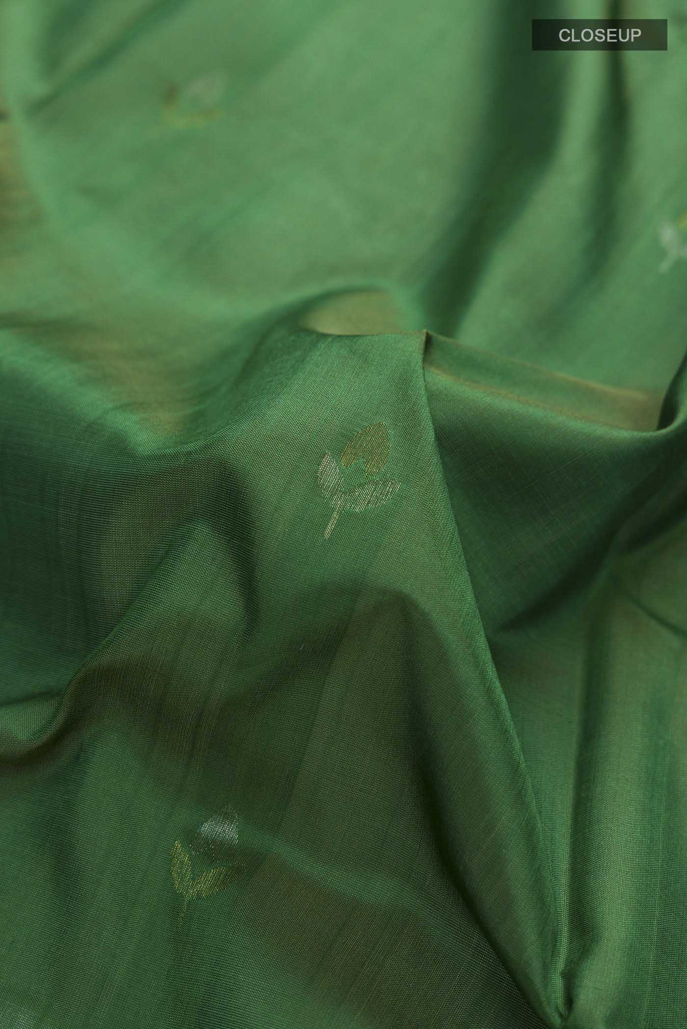 Close up of Green Uppada Silk Saree with Zari Butta on the body and Zari Border displaying folds