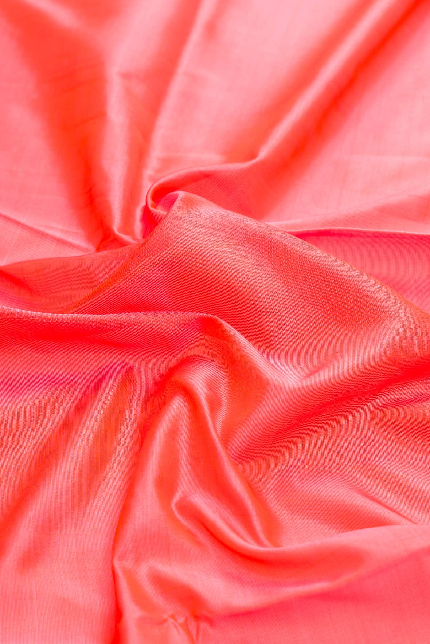 Close up of Coral Dual Tone Uppada Silk Saree with Plain Body and Zari Border displaying folds
