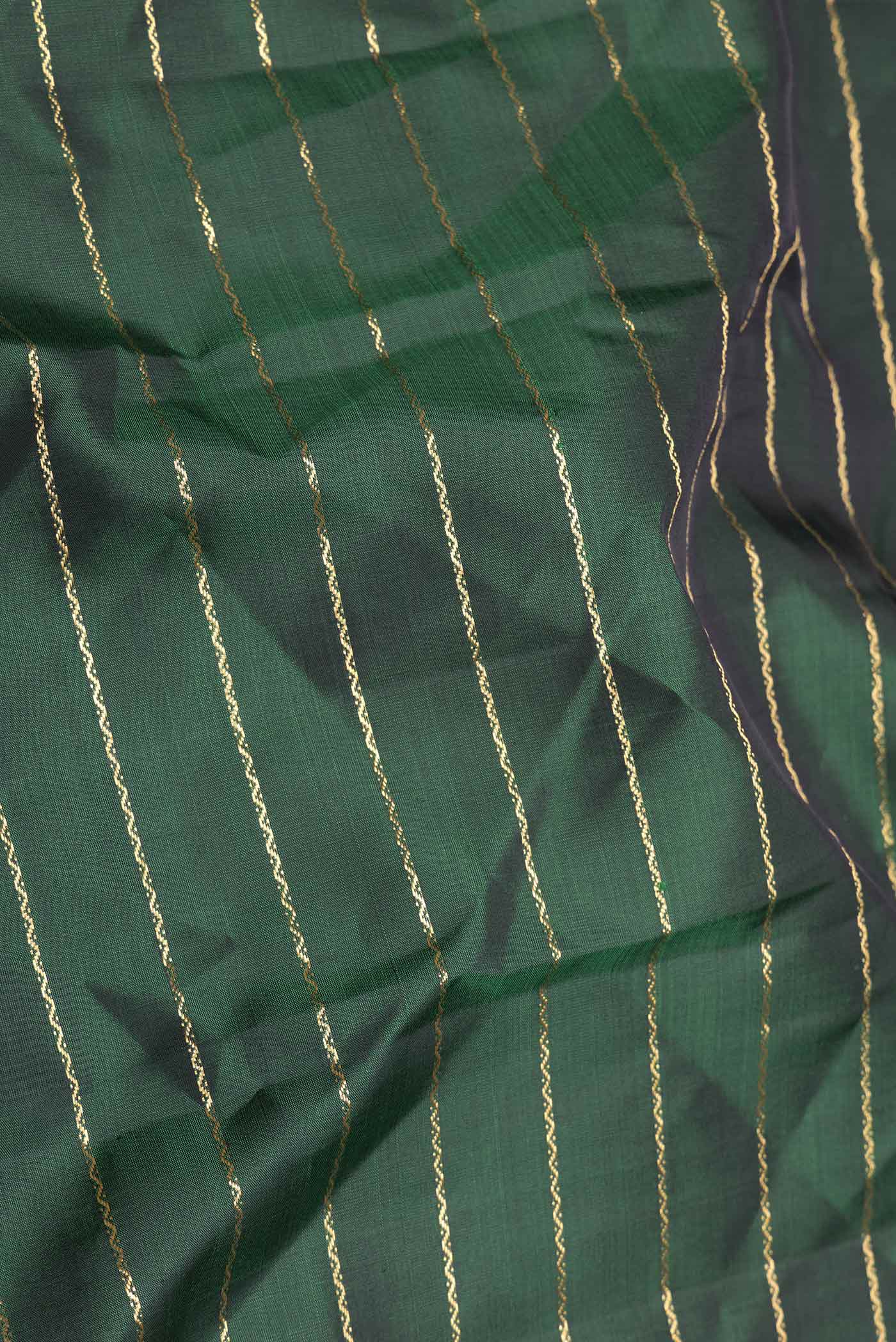 Close up of Green Dual Tone Kanchipuram Saree with Veldhari on the body and Zari Border displaying folds