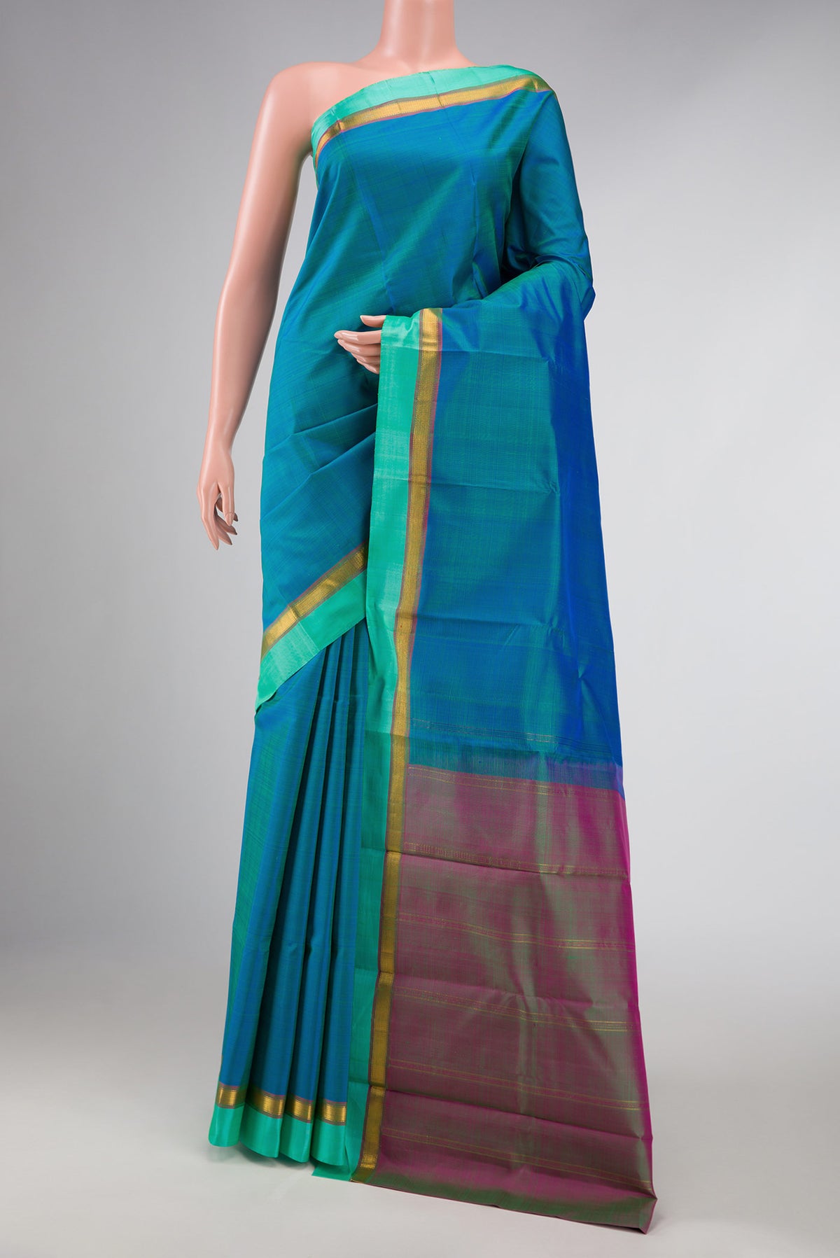 Peacock Blue Dual Tone Kanchipuram Silk Saree with Plain Body and Zari Border displayed on a mannequin
