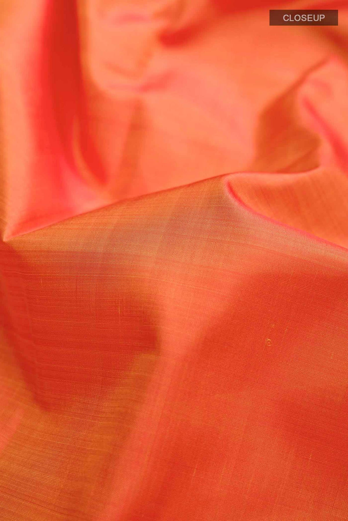 Close up of Orange Kanchipuram Silk Saree with Plain Body and Zari Border displaying folds