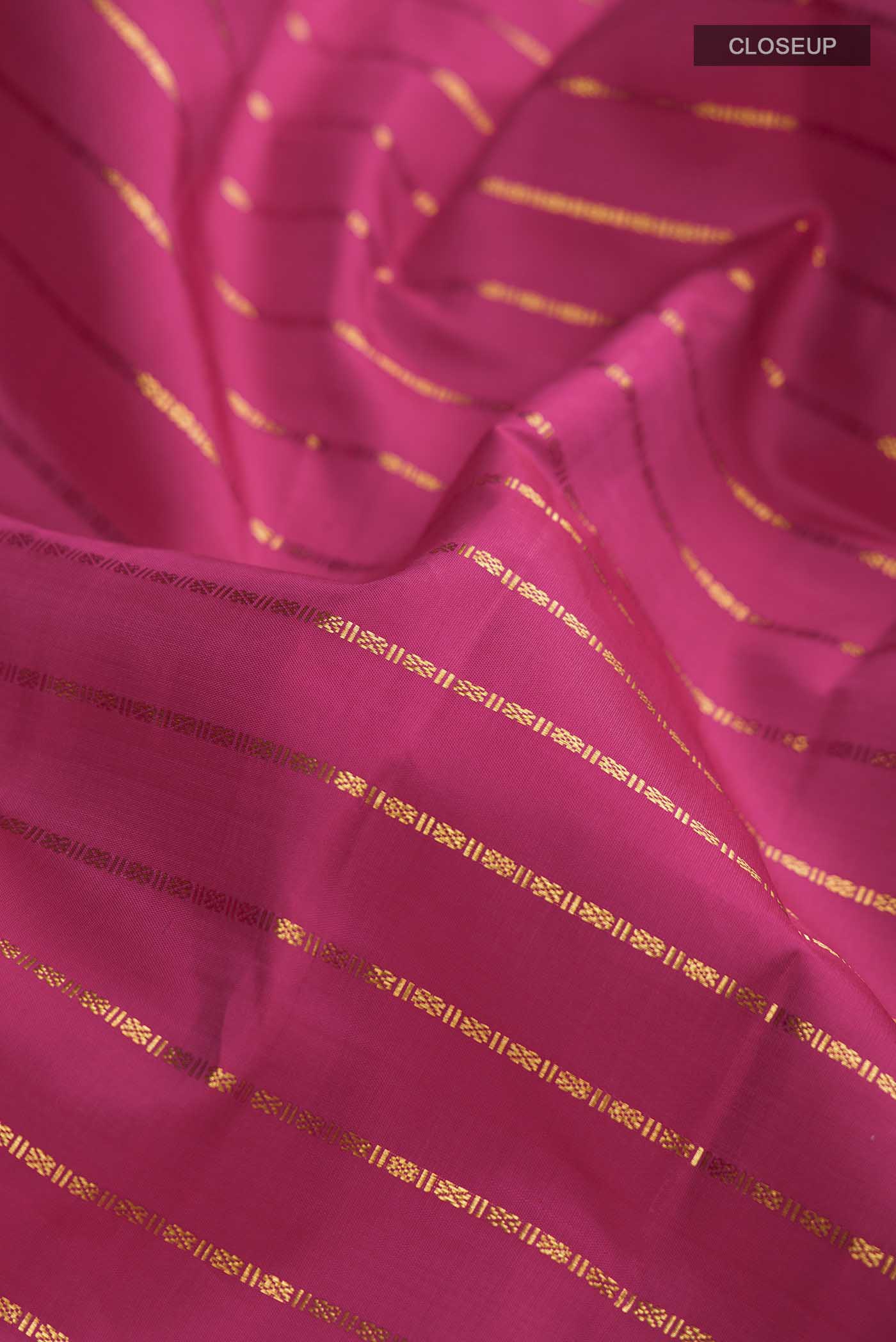 Close up of Pink Kanchipuram Silk Saree with Stripes on the body and Zari Border displaying folds