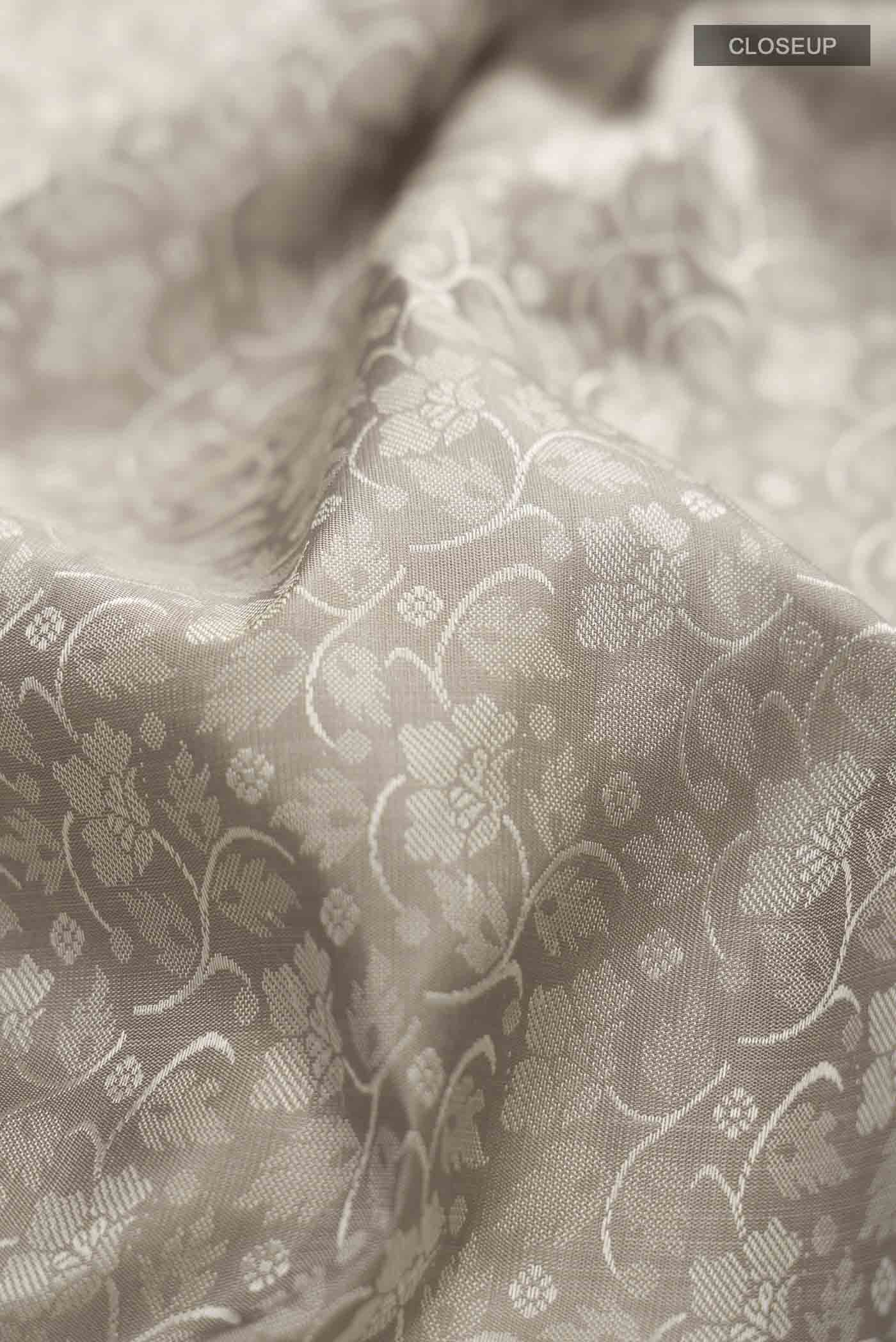Close up of Grey Kanchipuram Silk Saree with Jacquard design on the body and Zari Border displaying folds