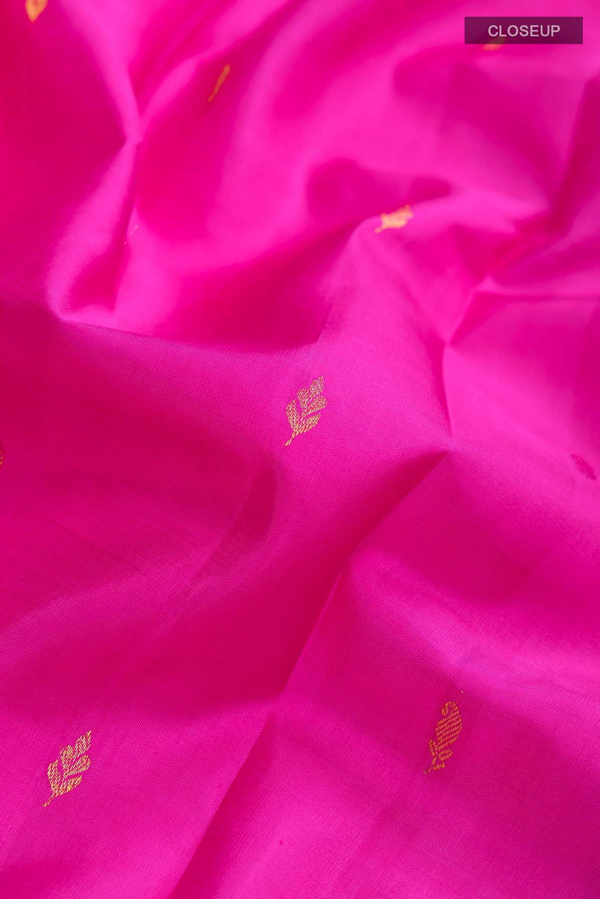 Close up of Pink Kanchipuram Silk Saree with Zari Butta on the body and Zari Border displaying folds