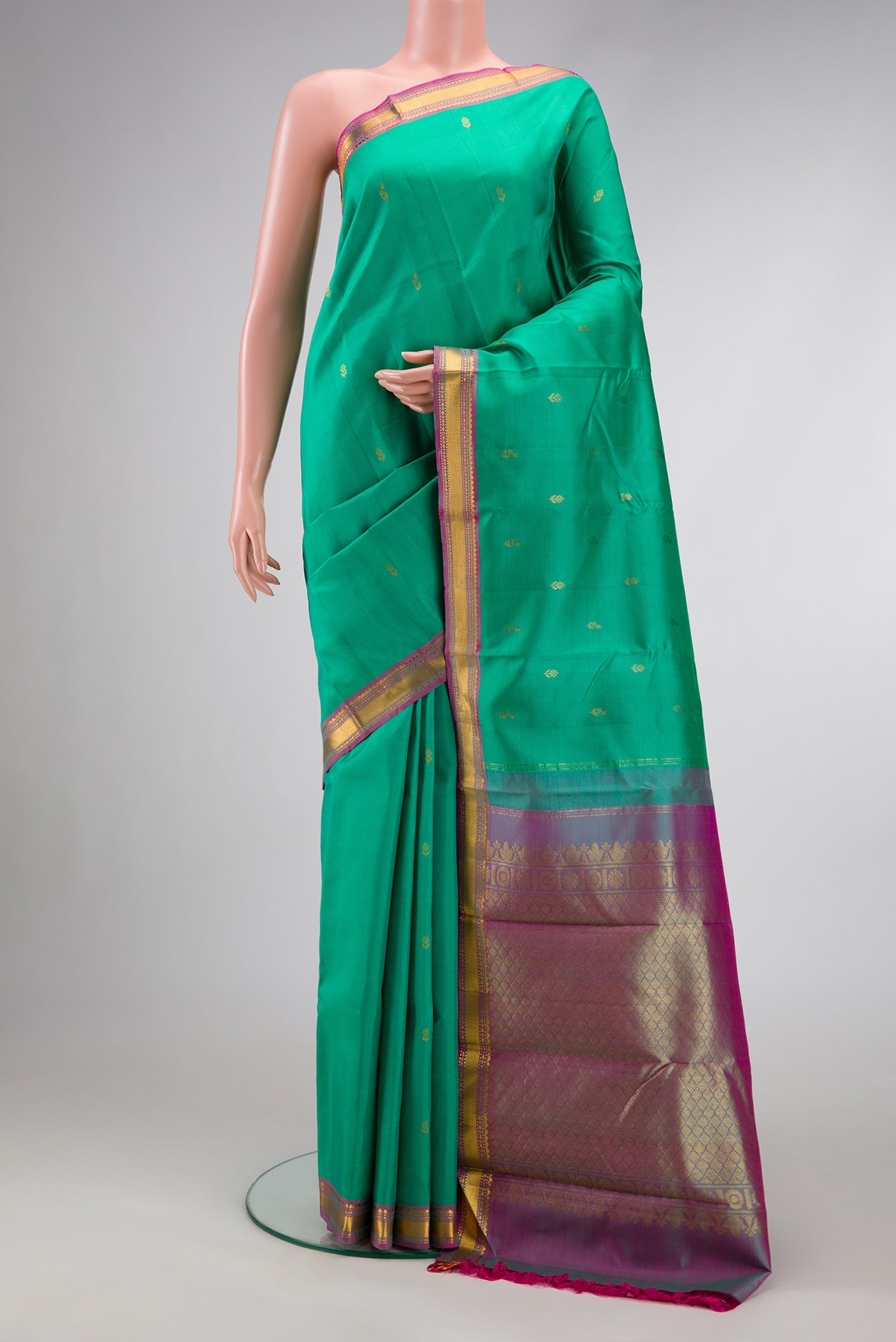 Green Dual Tone Kanchipuram Silk Saree with Zari Butta on the body and Zari Border.  displayed on a mannequin
