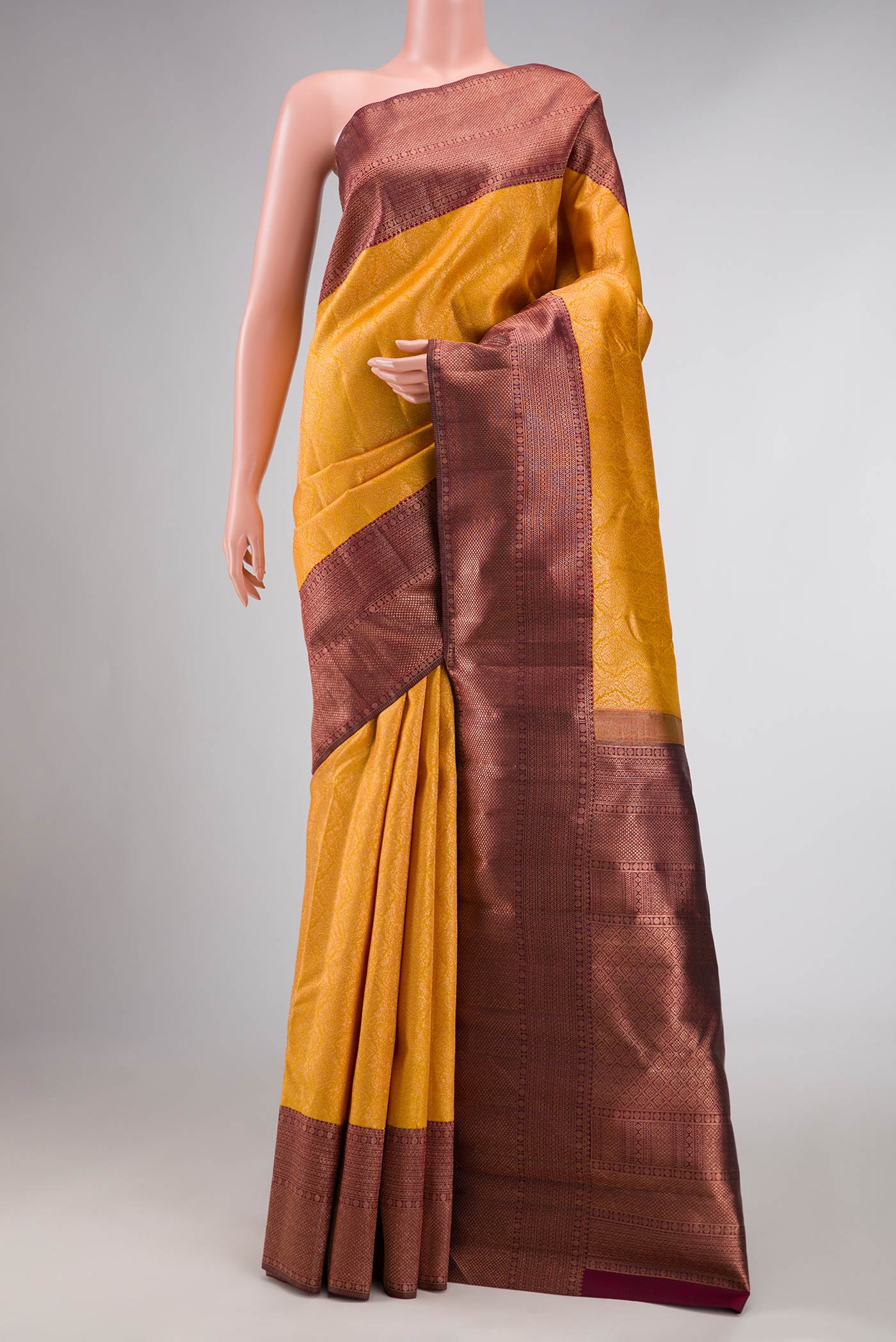 Mustard Dual Tone Kanchipuram Silk Saree with Zari Brocade on the body and Zari Border displayed on a mannequin