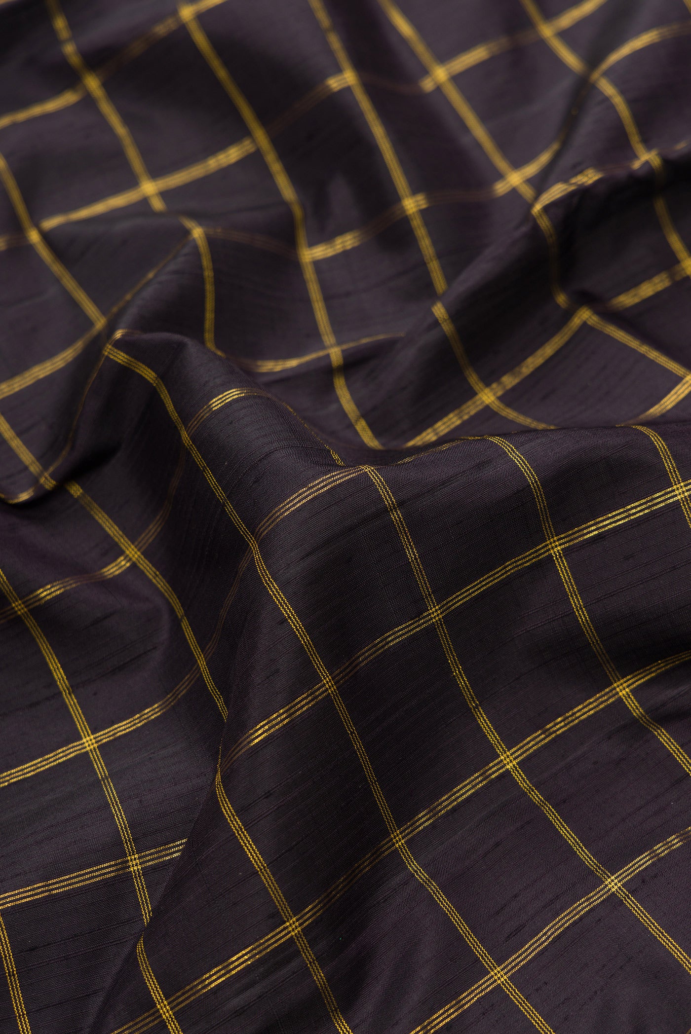 Close up of Black Dual Tone Kanchipuram Silk Saree with Checked design on the body and Zari Border.  displaying folds