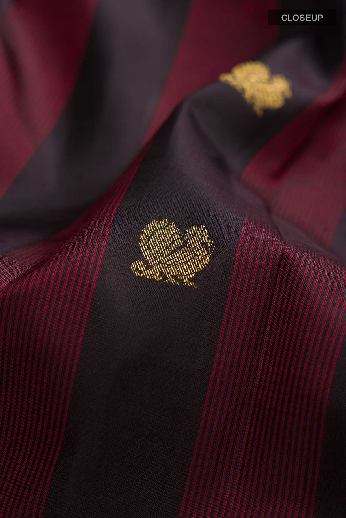 Close up of Black Kanchipuram Silk Saree with Zari Butta on the body and Zari Border displaying folds