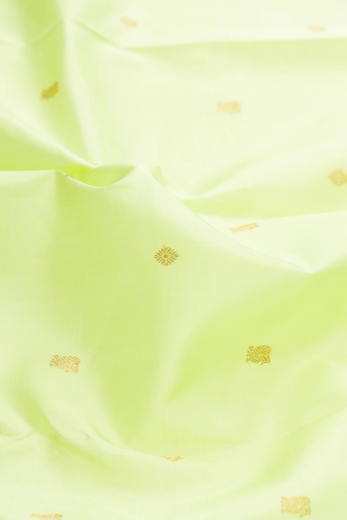 Close up of Pure Silk Pure Zari Parrot Green Dual Tone Kanchipuram Saree with Zari Butta on the body and Zari Border displaying folds