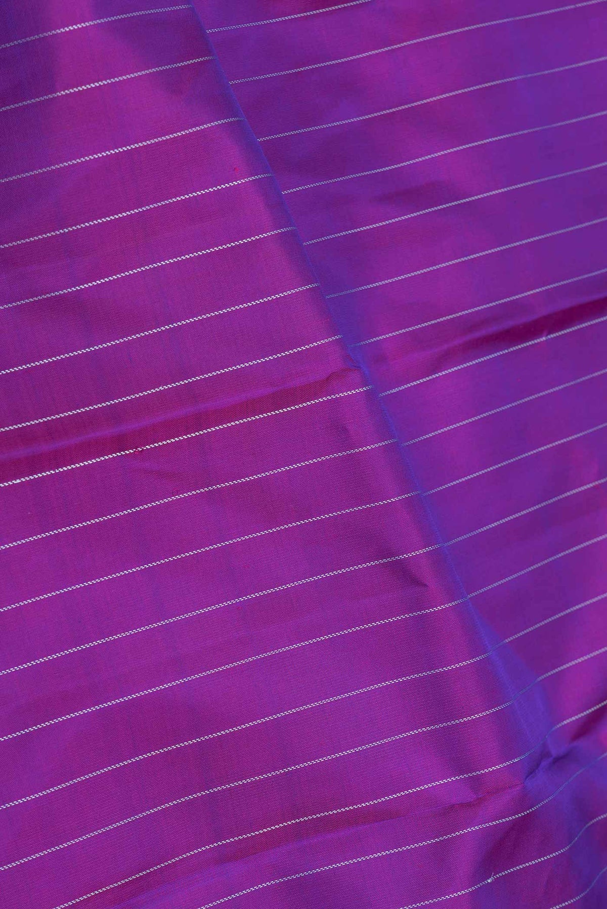 Close up of Purple Dual Tone Kanchipuram Saree with Stripes on the body and Fancy Border displaying folds