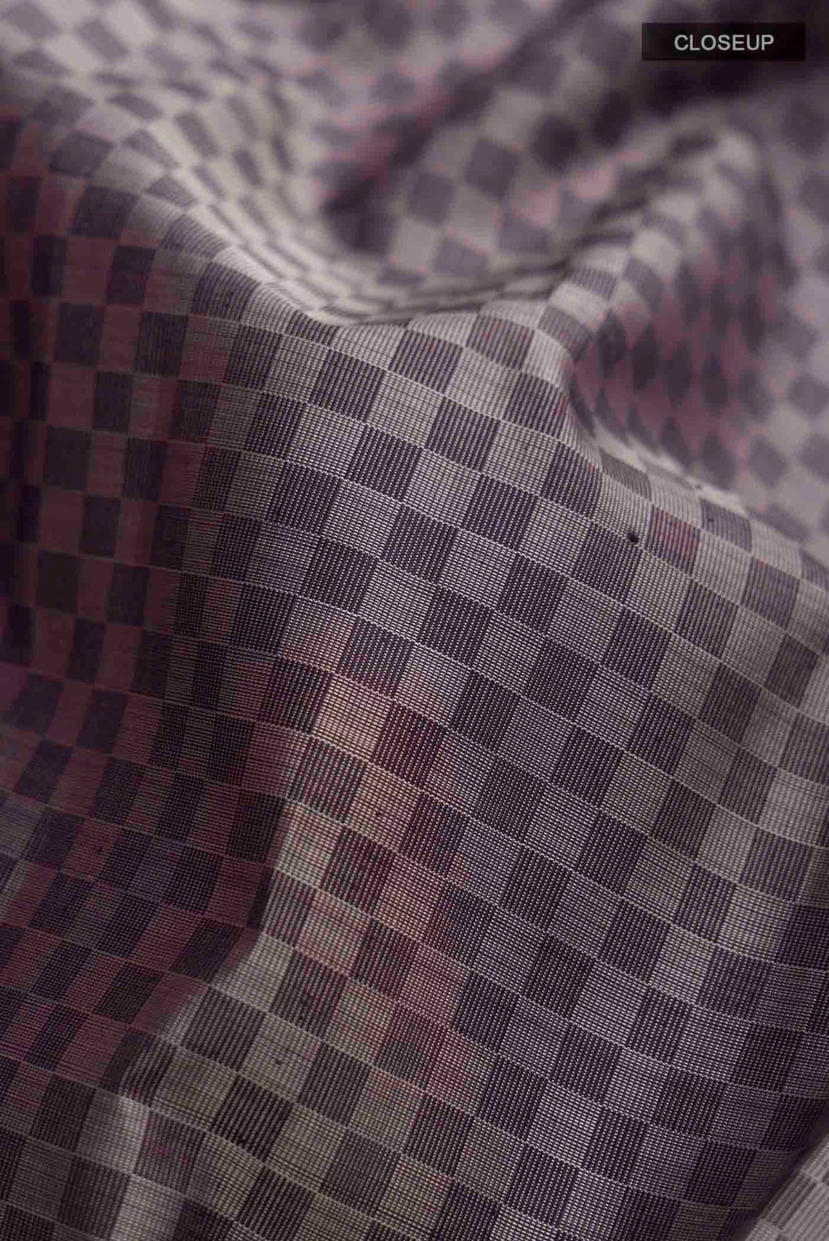 Close up of Grey Kanchipuram Silk Saree Checked design on the body and Zari Border displaying folds