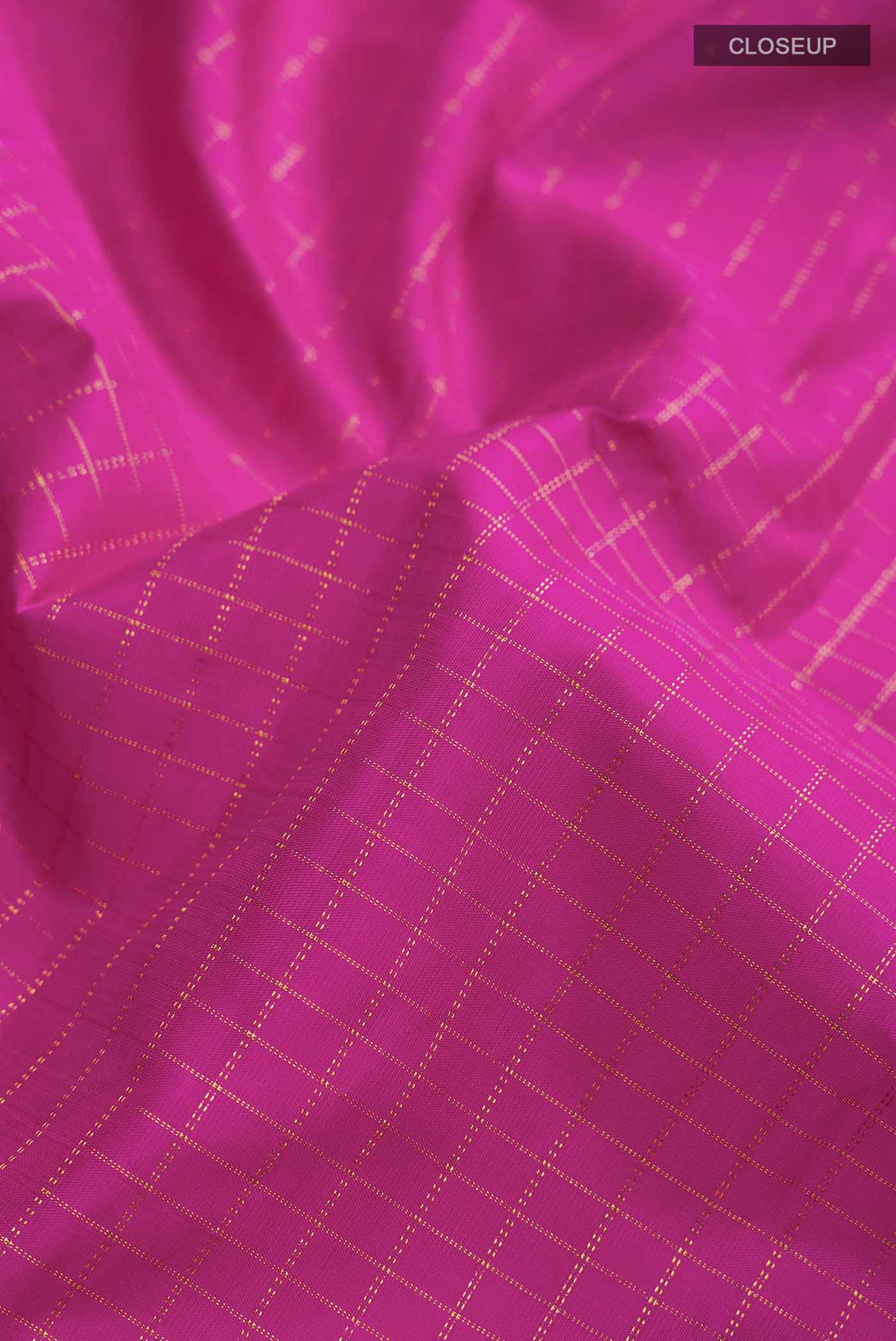 Close up of Pink Kanchipuram Silk Saree with Checked design on the body and Zari Border displaying folds