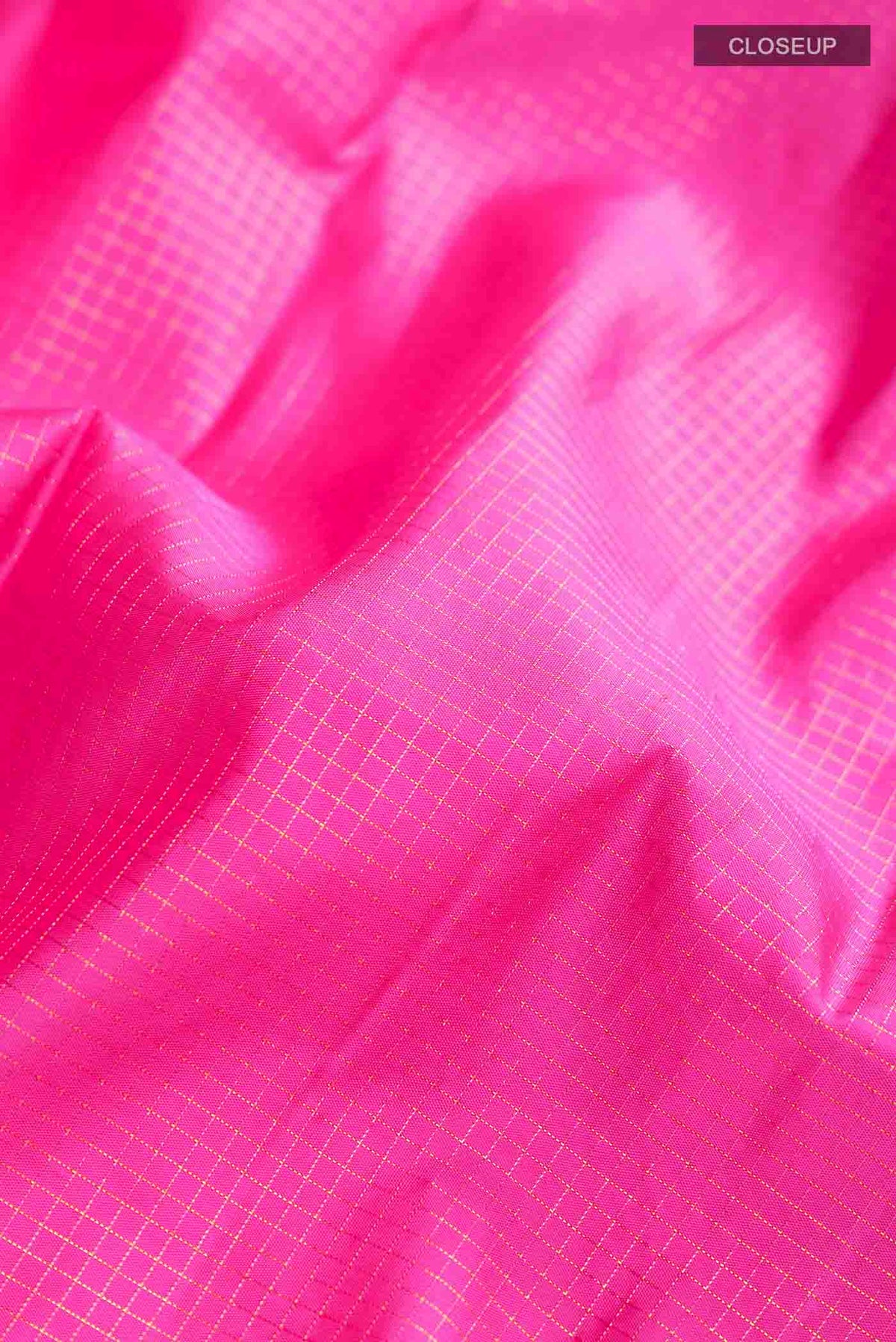 Close up of Pink Kanchipuram Silk Saree with Checked design on the body and Zari Border displaying folds