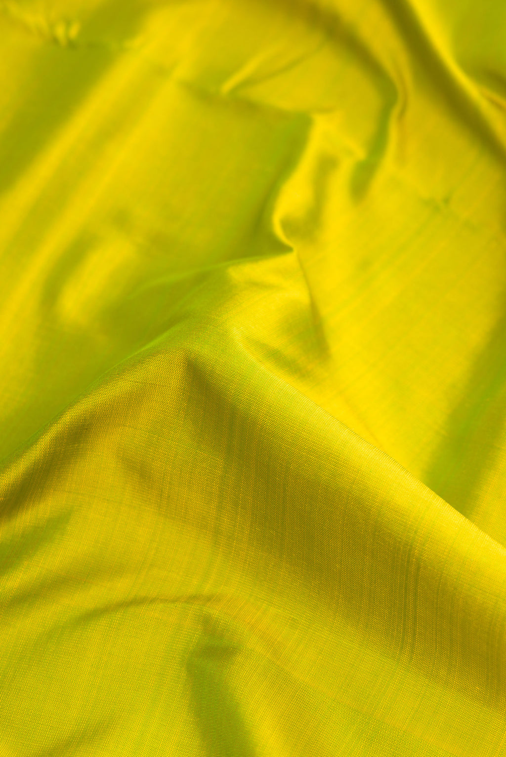 Close up of Pure Silk Pure Zari Parrot Green Dual Tone Kanjivaram Nine Yards Saree with Plain Body and Zari Border.  displaying folds