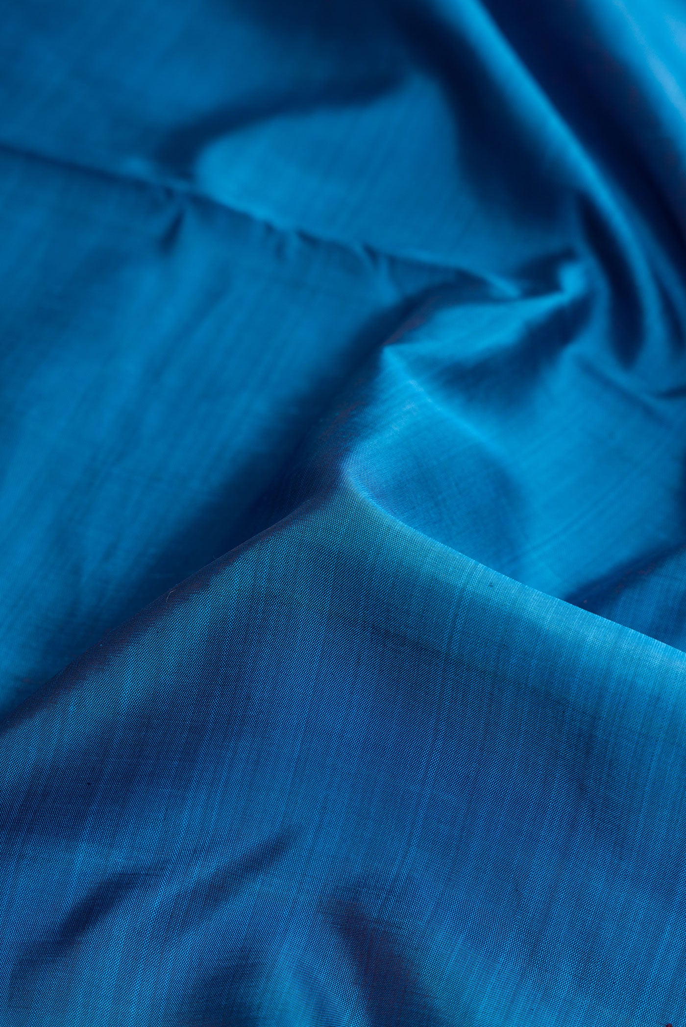 Close up of Pure Silk Pure Zari Peacock Blue Dual Tone Kanjivaram Nine Yards Saree with Plain Body and Zari Border.  displaying folds