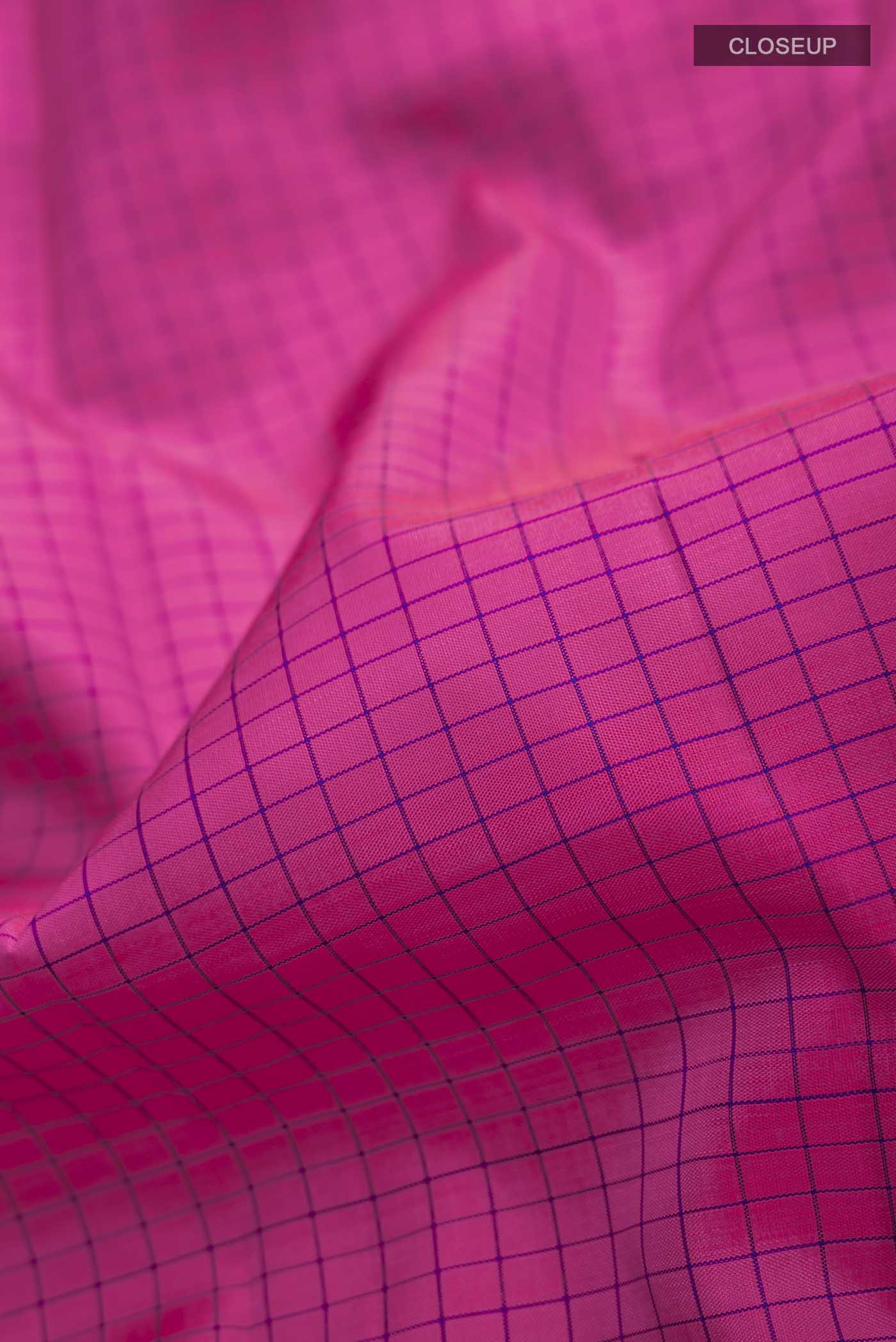 Close up of Pink Kanchipuram Silk Saree with Checked design on the body and Zari Border displaying folds