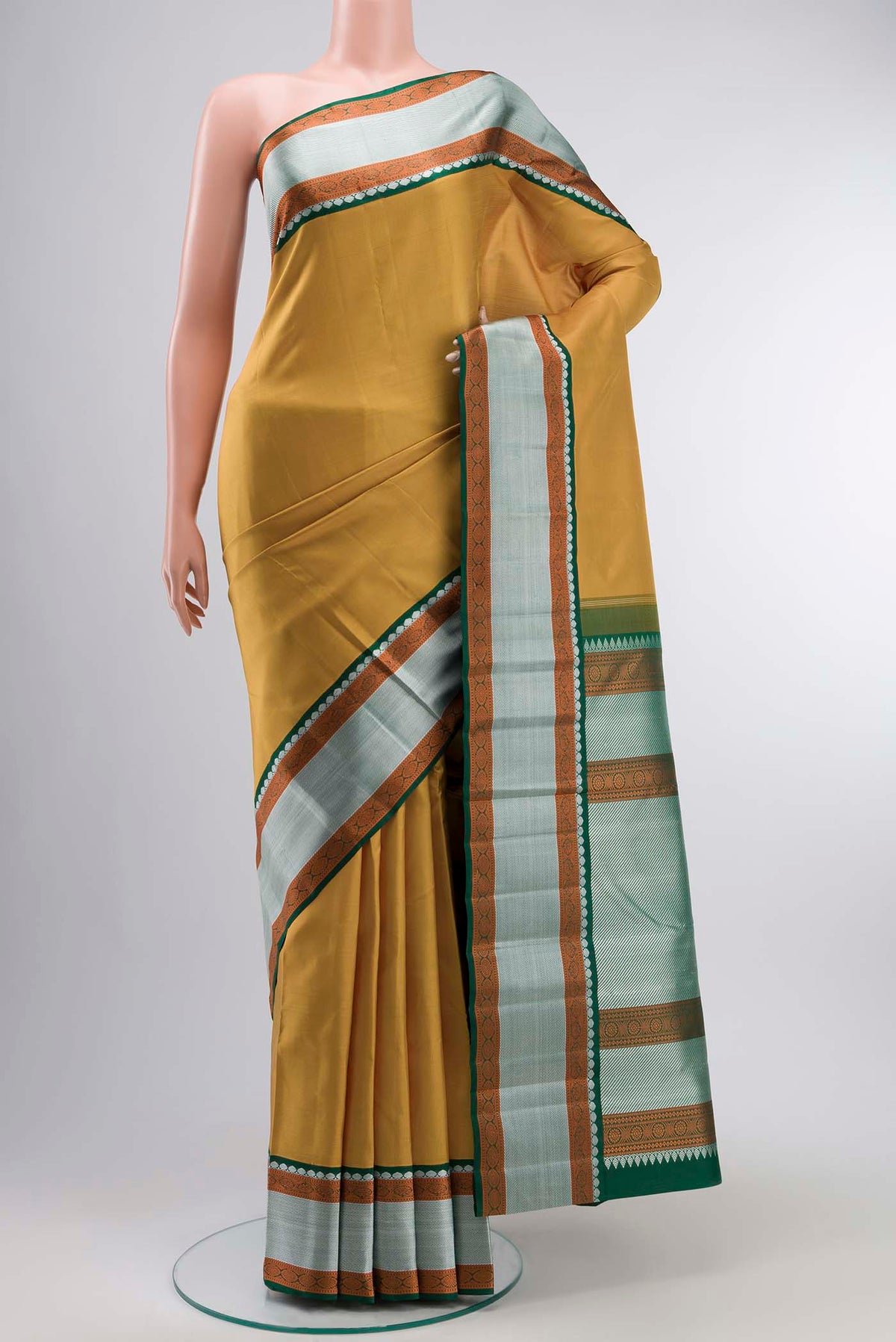 Mustard Kanchipuram Silk Saree with Plain Body and Zari Border displayed on a mannequin