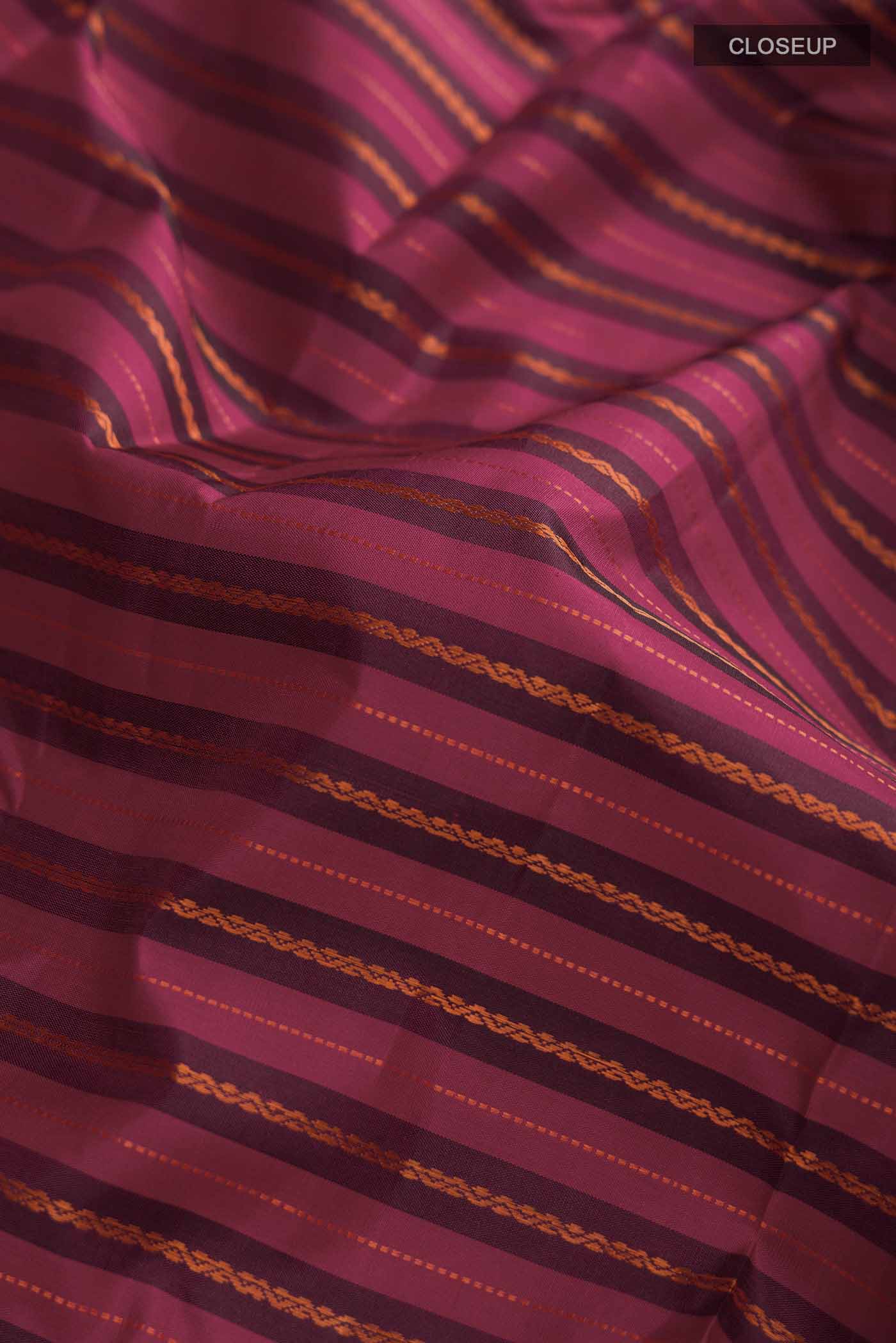 Close up of Maroon Kanchipuram Silk Saree with Stripes on the body and Zari Border displaying folds