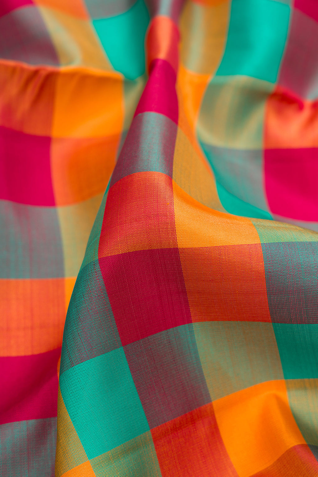 Close up of Pure Silk Pure Zari Green , Pink and Orange Color Kanchipuram Nine Yards Saree with Checked design on the body and Zari Border.  displaying folds