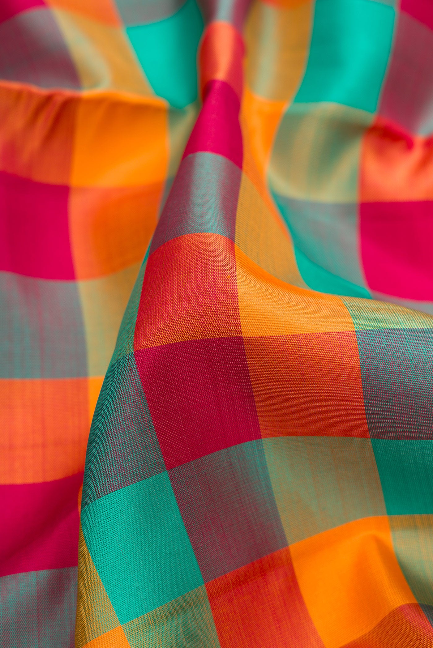 Close up of Pure Silk Pure Zari Green , Pink and Orange Color Kanchipuram Nine Yards Saree with Checked design on the body and Zari Border.  displaying folds