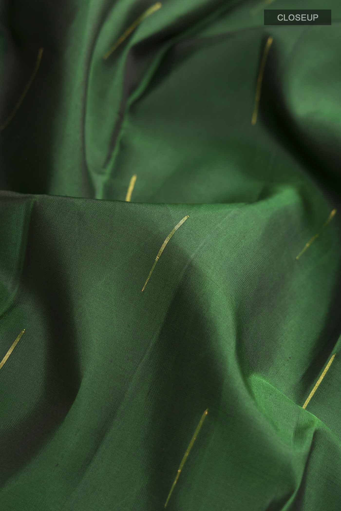 Close up of Green Kanchipuram Silk Saree with Zari Butta on the body and Zari Border displaying folds