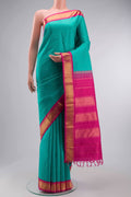 Green Kanchipuram Silk Saree with Plain Body and Zari Border displayed on a mannequin
