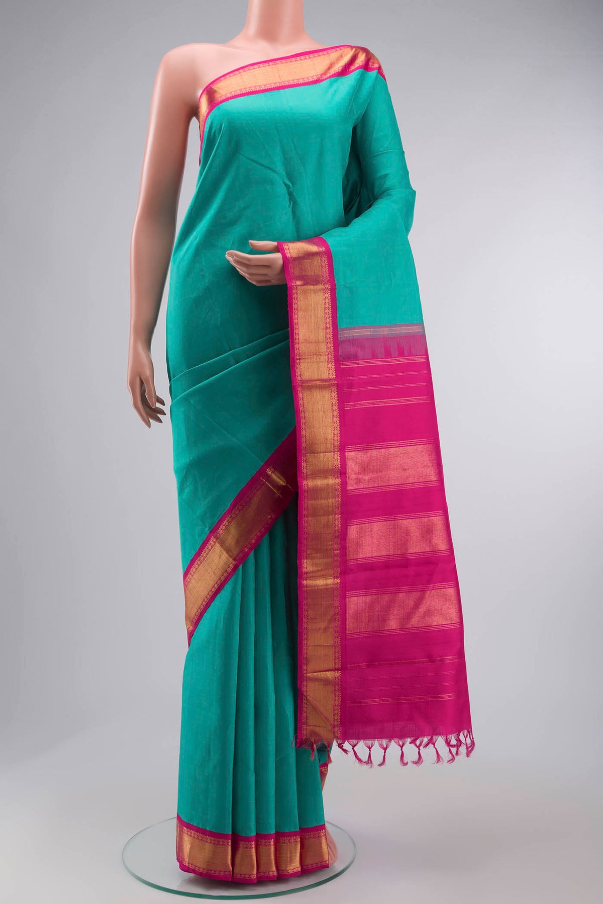 Green Kanchipuram Silk Saree with Plain Body and Zari Border displayed on a mannequin
