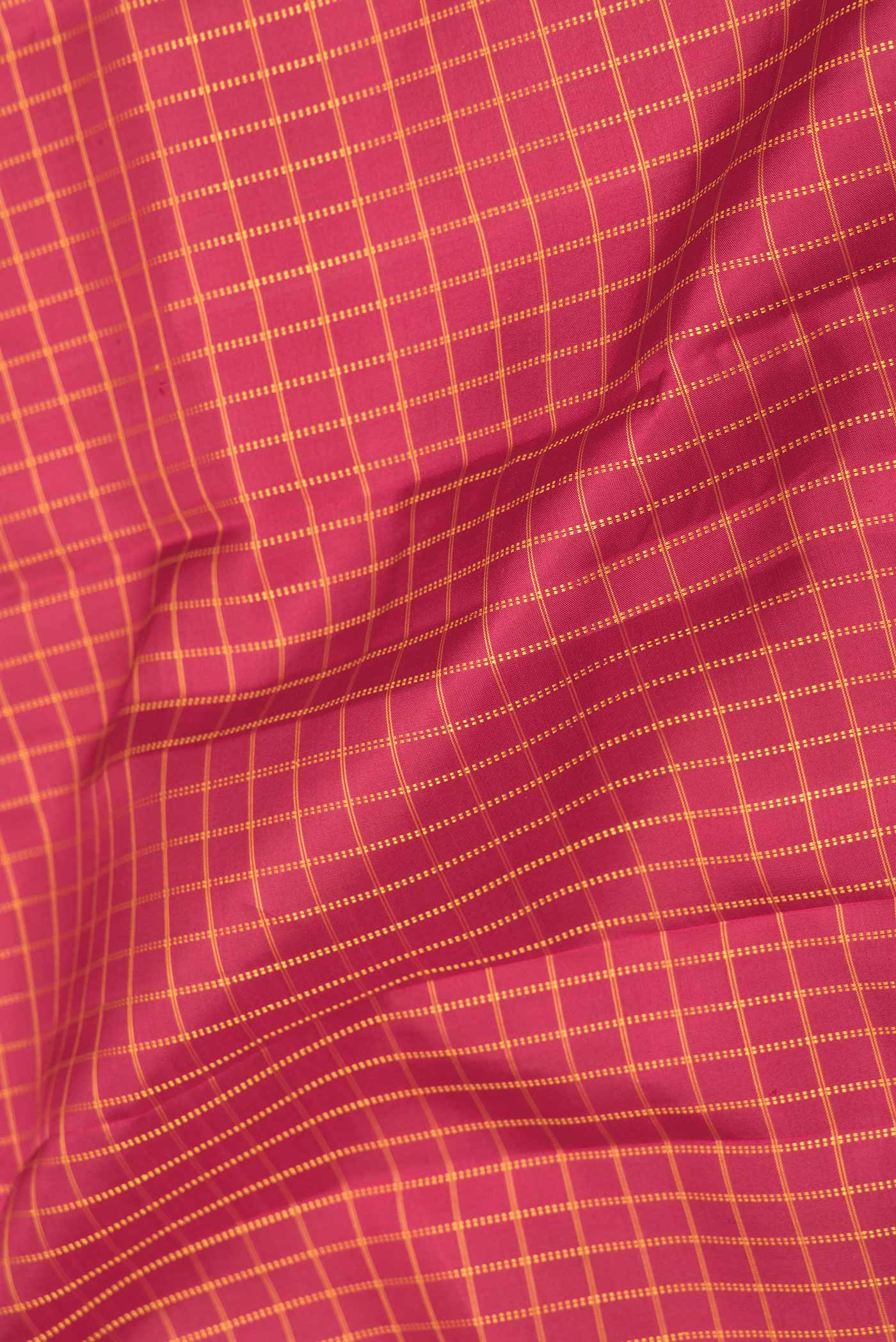 Close up of Maroon Dual Tone Kanchipuram Saree with Checked design on the body and Zari Border displaying folds