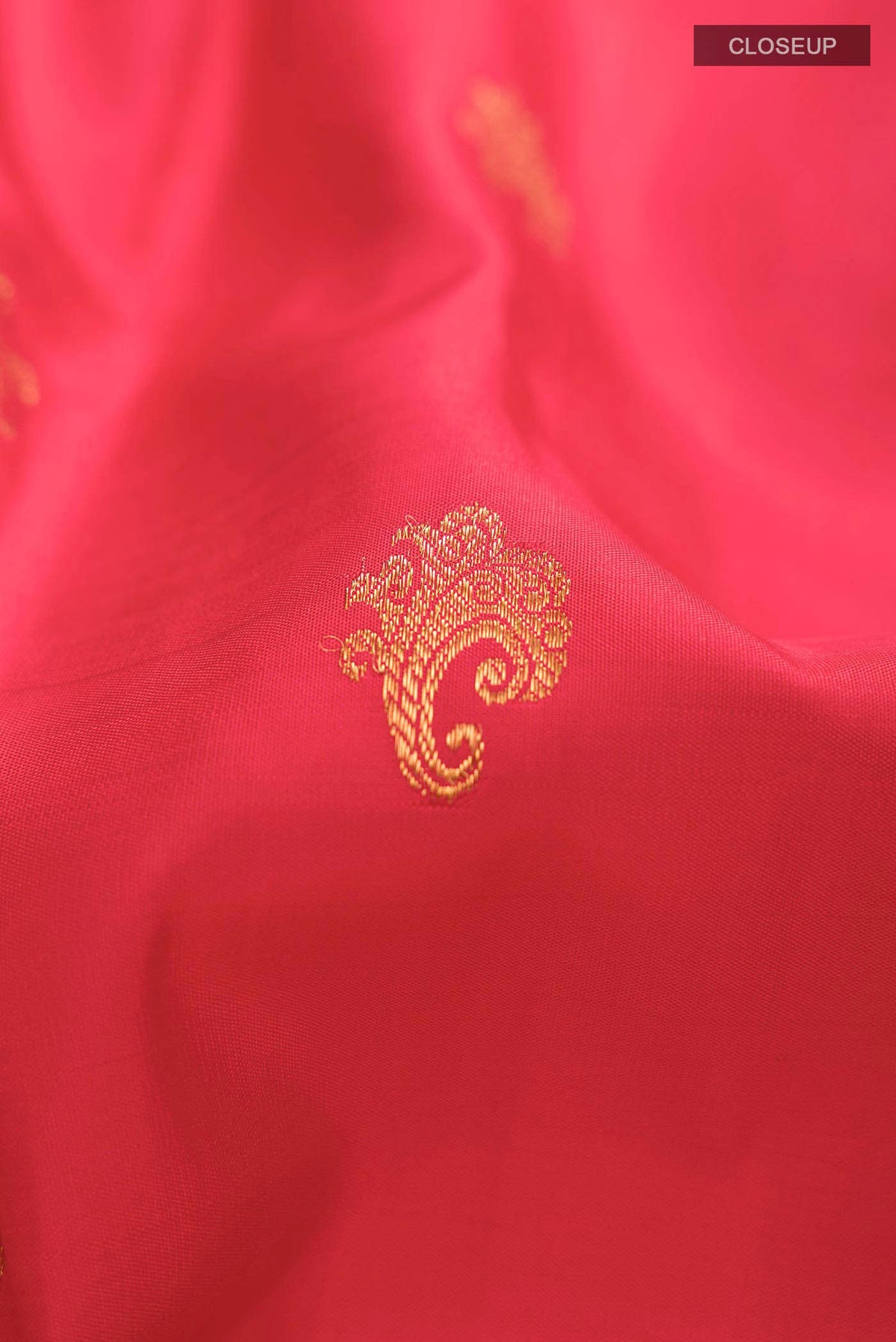 Close up of Red Kanchipuram Silk Saree with Zari Butta on the body and Zari Border displaying folds