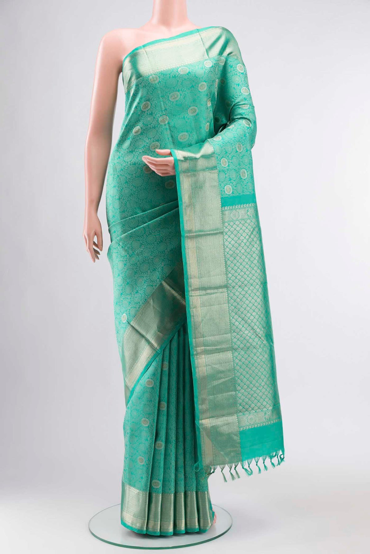 Turquoise Kanchipuram Silk Saree with Zari And Thread Butta on the body and Zari Border displayed on a mannequin