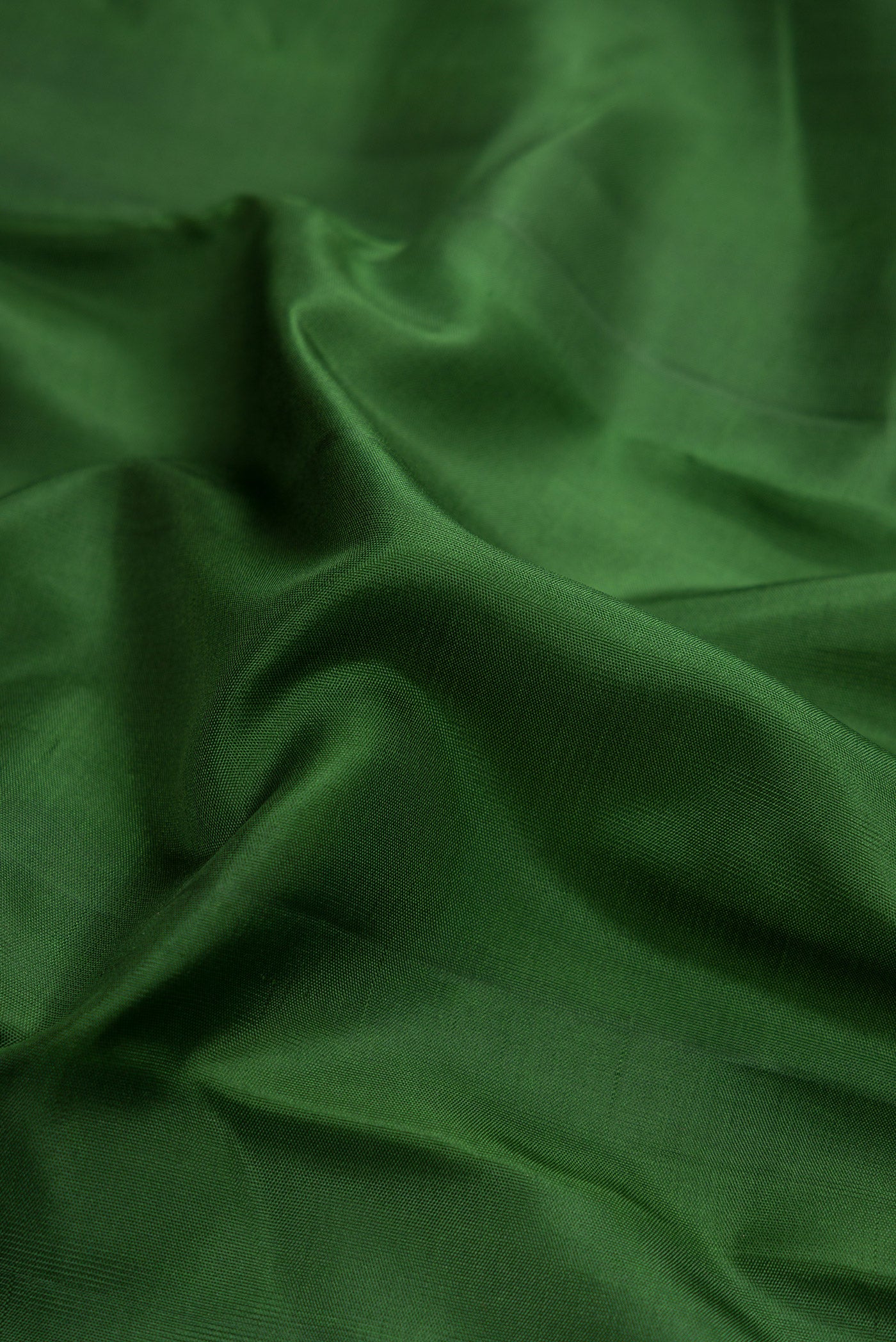 Close up of Bottle Green Dual Tone Soft Silk Saree with Plain Body and Zari Border.  displaying folds