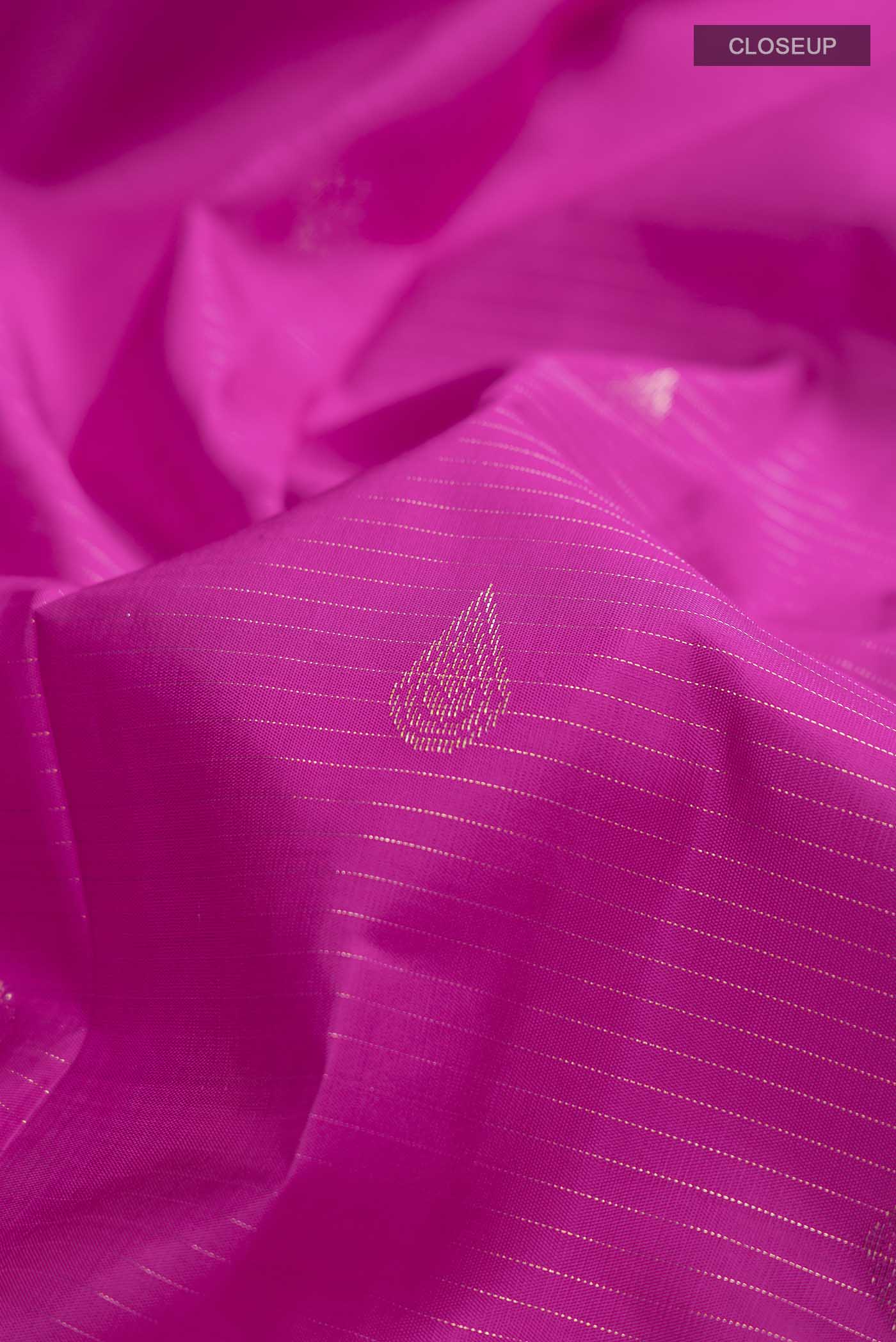 Close up of Pink Kanchipuram Silk Saree with Zari Butta on the body and Zari Border displaying folds