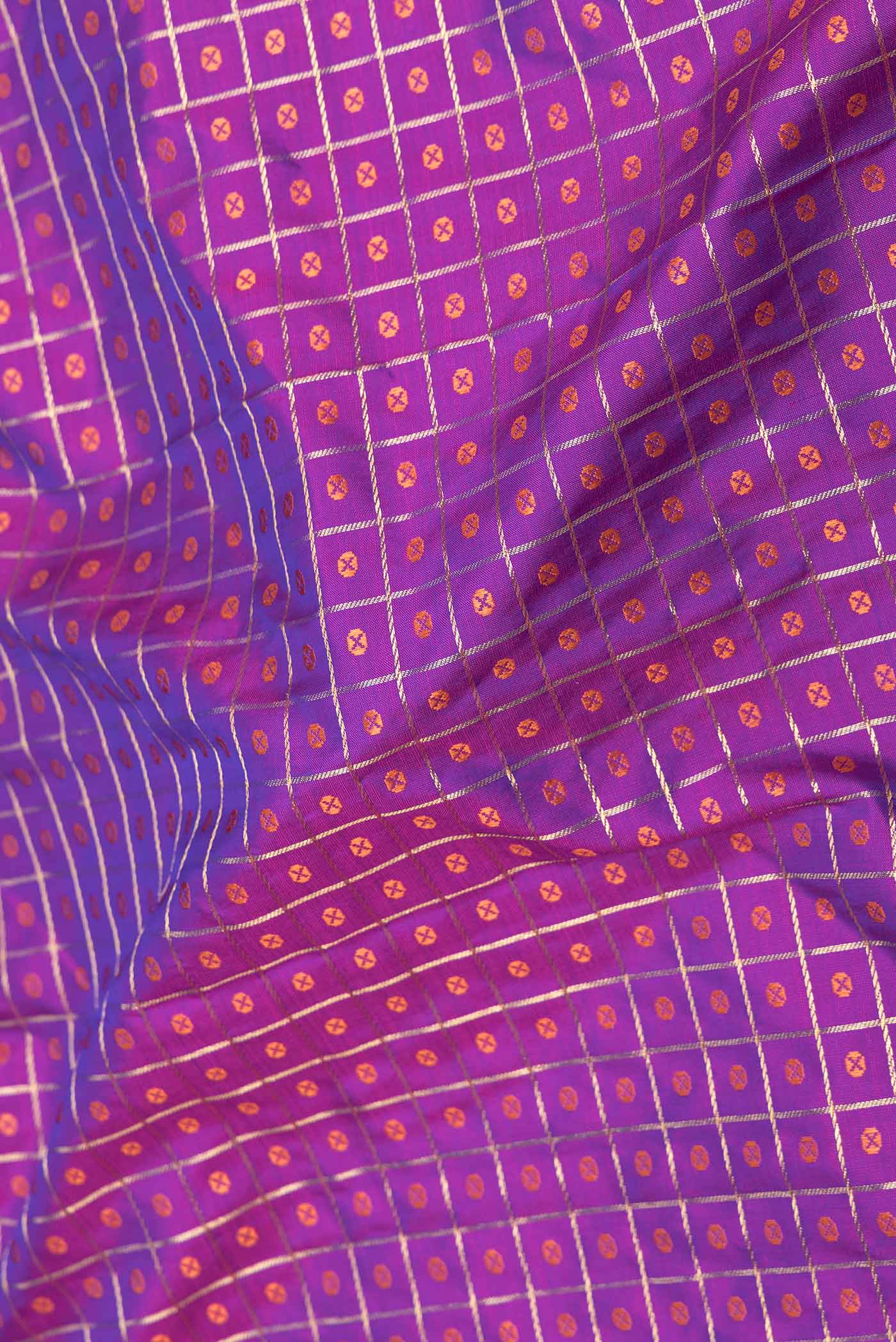 Close up of Purple Dual Tone Kanchipuram Saree with Zari And Thread Butta on the body and Zari Border displaying folds