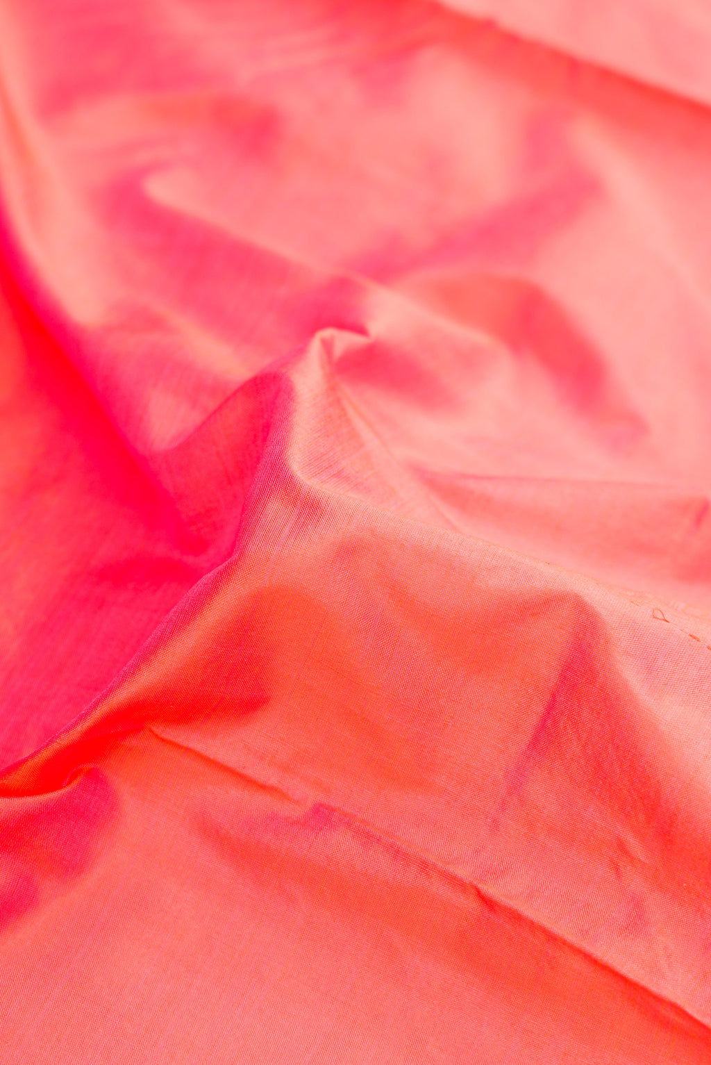 Close up of Coral Dual Tone Kanjivaram Silk Nine Yards Saree with Plain Body and Zari Border.  displaying folds