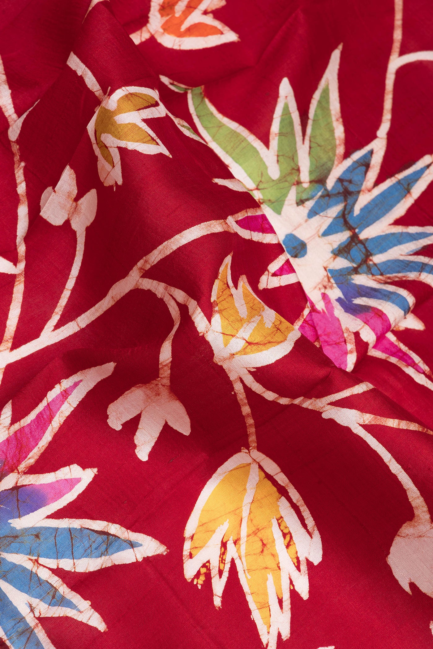 Close up of Maroon Printed Silk Saree with Batik Print on the body and Printed Border.  displaying folds